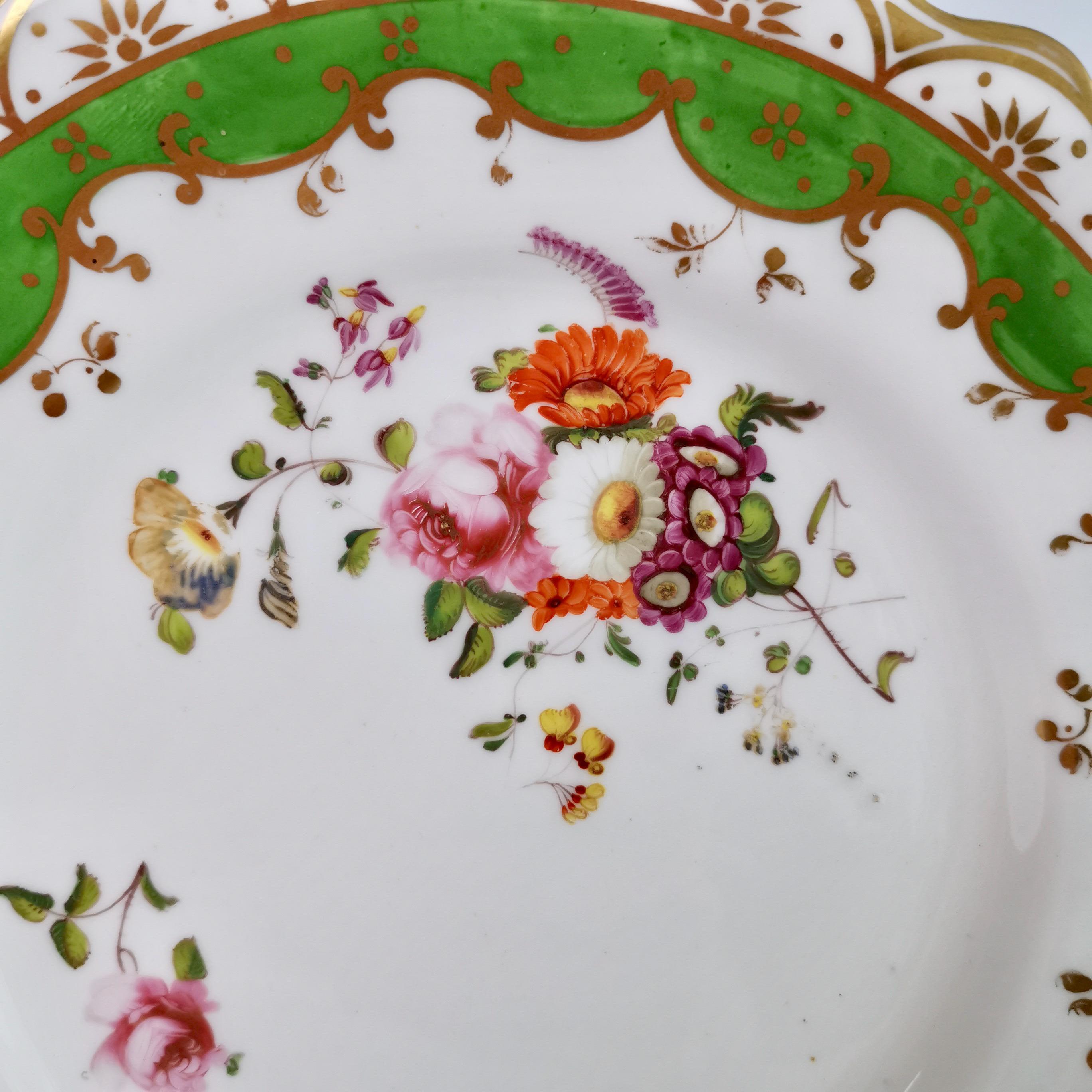 This is a very beautiful plate made by Ridgway around 1832. The plate has a bright green ground, daisy moulding on its two handles, and beautiful hand painted flowers. 
 
We know from the pattern number that this plate would have formed part of a