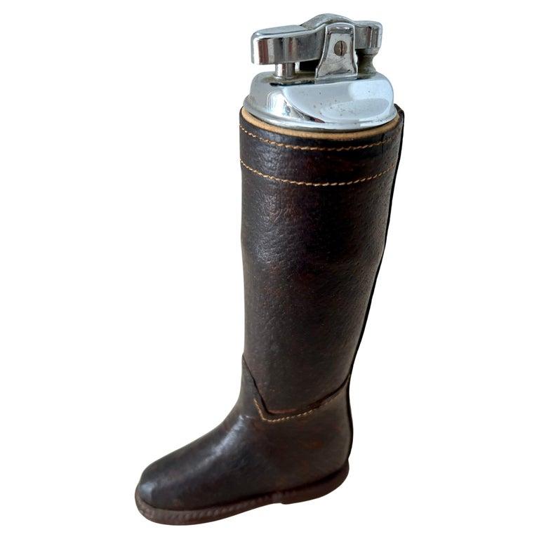 A leather riding boot lighter. A compliment to many settings, from desks to work stations and cocktail tables. The perfect gift for a horse rider or breeder - or someone that loves the track.  The lighter has been re-conditioned and lights great!

A