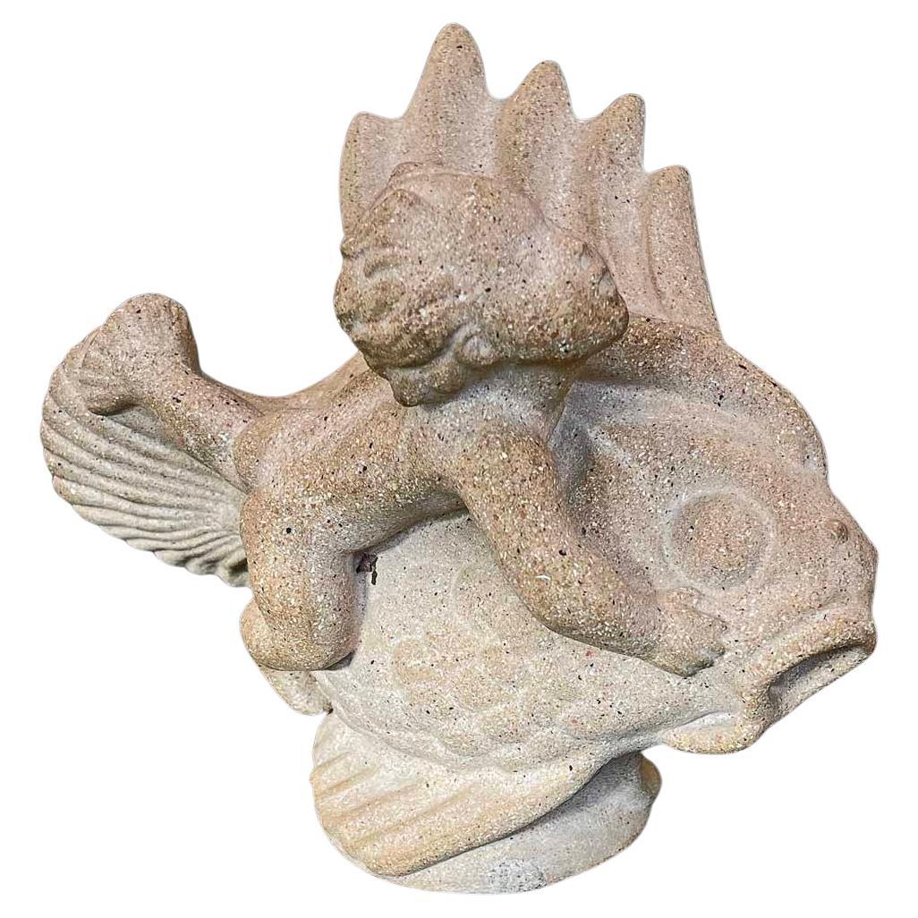 Gioiosa e piena di energia, questa rara - forse unica - scultura di Just Andersen raffigura un merboy, con tanto di pinne ai piedi, che cavalca un pesce grassoccio attraverso il mare, con la bocca aperta per la meraviglia.  Il materiale è un gres