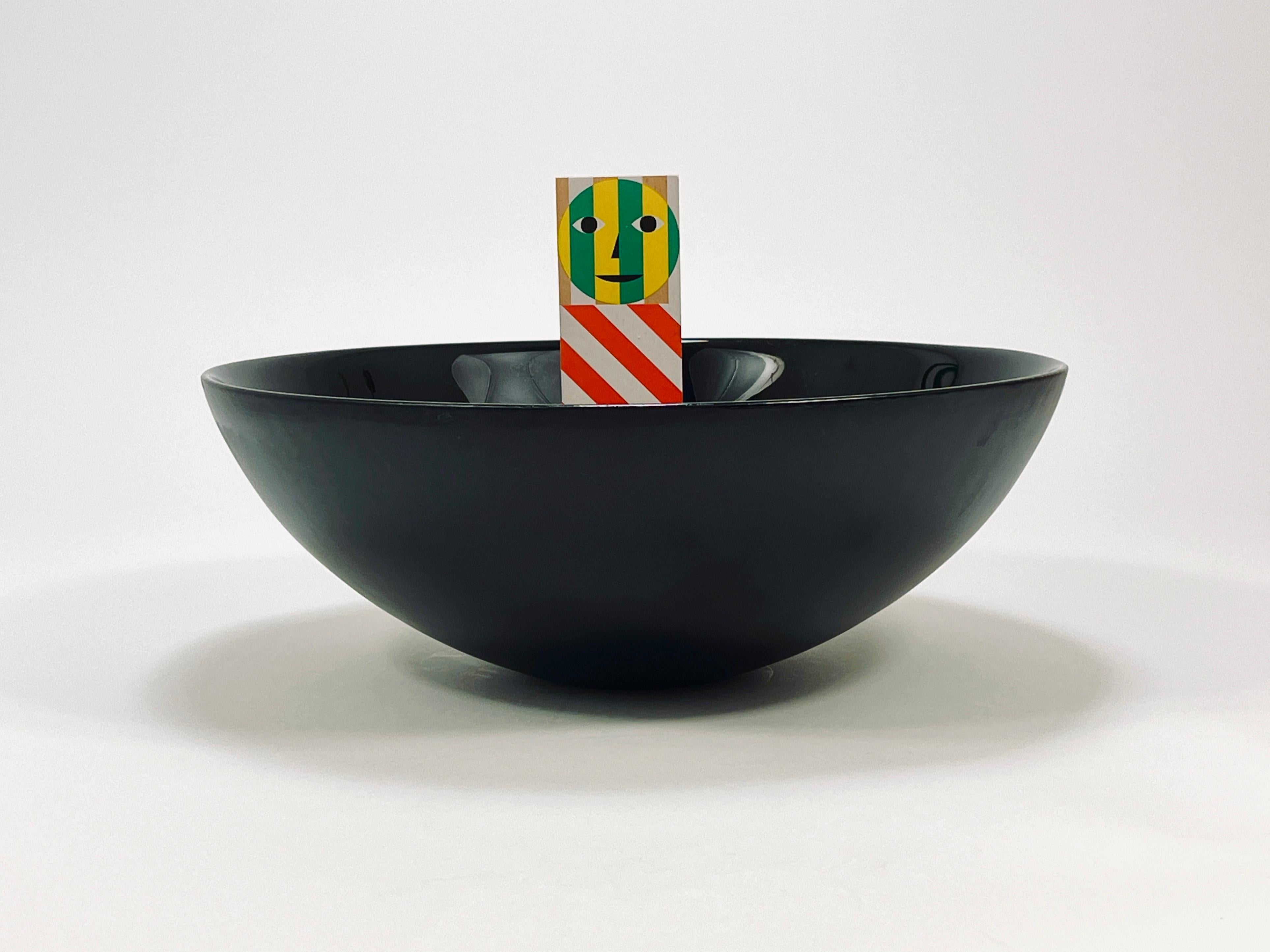 Un cuenco de cristal postmoderno recto y grande, de 14 pulgadas de diámetro, de la década de 1980. Fabricado en vidrio negro intenso, este cuenco destaca por su diseño reducido y elegante, con un interior muy brillante y un exterior mate. Forma