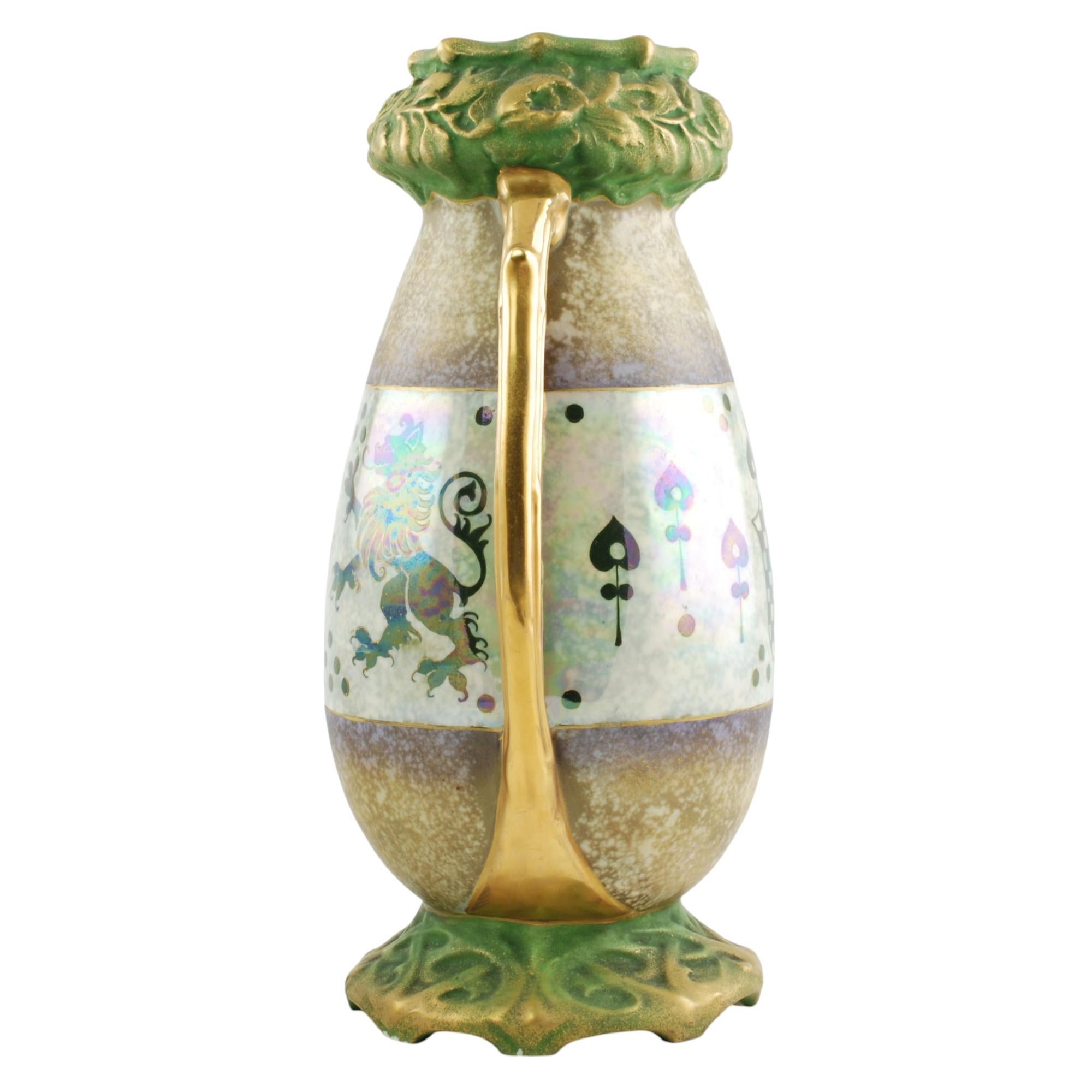 Este llamativo jarrón Art Nouveau de ánfora fue fabricado en la región de Turn-Teplitz (Bohemia) por Riessner, Stellmacher & Kessel, fundada en 1892. El jarrón tiene forma ovoide con una gruesa banda moldeada floral y foliada situada en el cuello.
