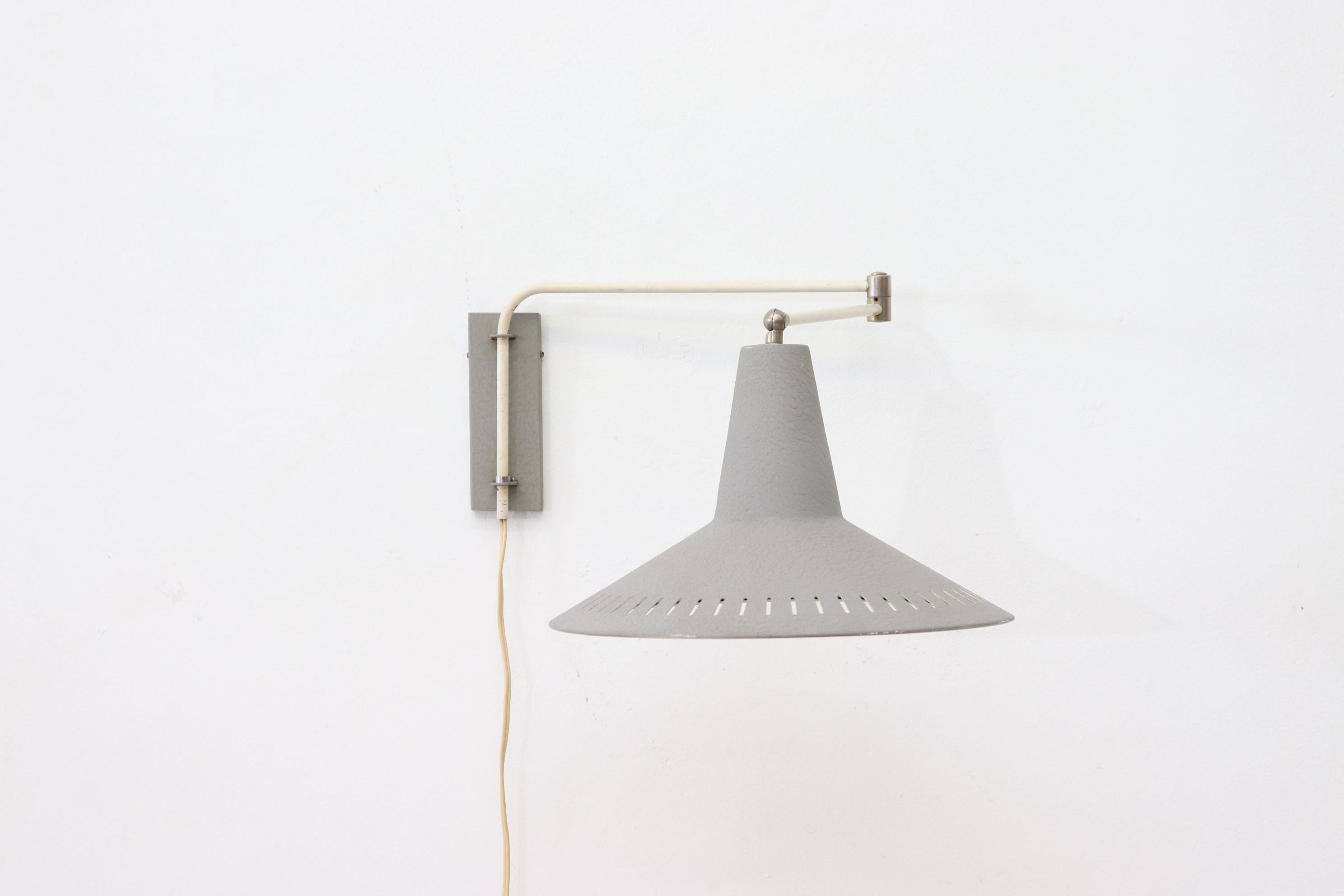 Rietveld style industrial wall mount lamp with grey textured metal shade and matching wall mount on an articulating arm. In original condition with wear consistent with age. Similar Sconces available (LU922415503082) and listed separately.