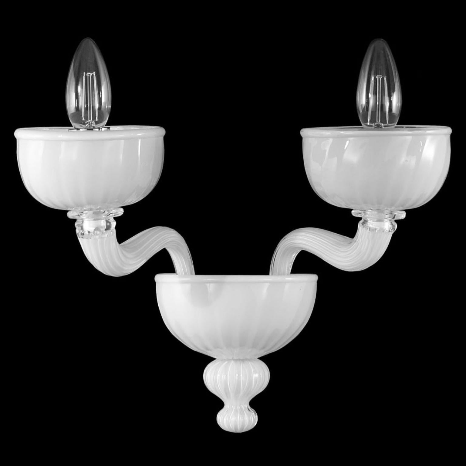 Rigadin sconce 2 arms white Murano glass by Multiforme
Edgar collection stands out thanks to its harmonious and balanced shapes. It has a clean structure, whose elements are perfectly proportioned.
All the elements that form either the sconces or