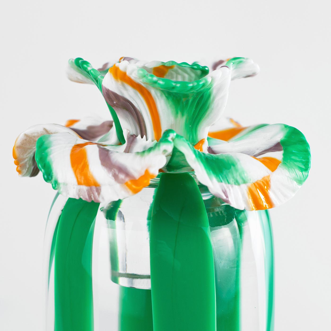 From the Rigadoni collection, this sculpture is characterized by bright green vertical stripes on transparent glass. Closing the vase is a Torcelo flower, crafted in white, coral, green and mauve stripes. Strictly decorative, the piece perfectly