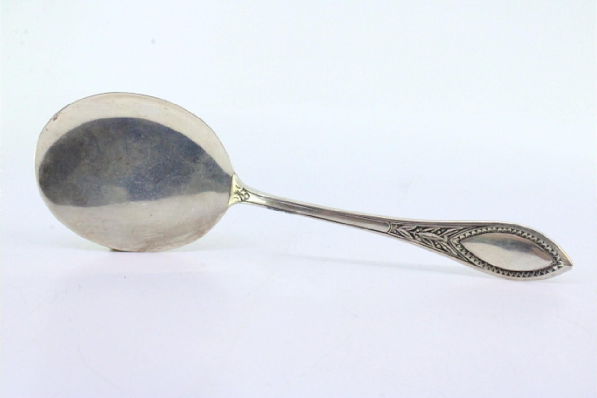 Descripción: Cuchara de helado plateada para diestros con ranuras a lo largo del mango que rodean una tarjeta con monograma. Metal: Silver. Origen: Europeo. Marca: Desconocida. Peso: 94,02 gramos. Dimensiones: 23cmx7cm. Contenido: 830/1000. Marca de