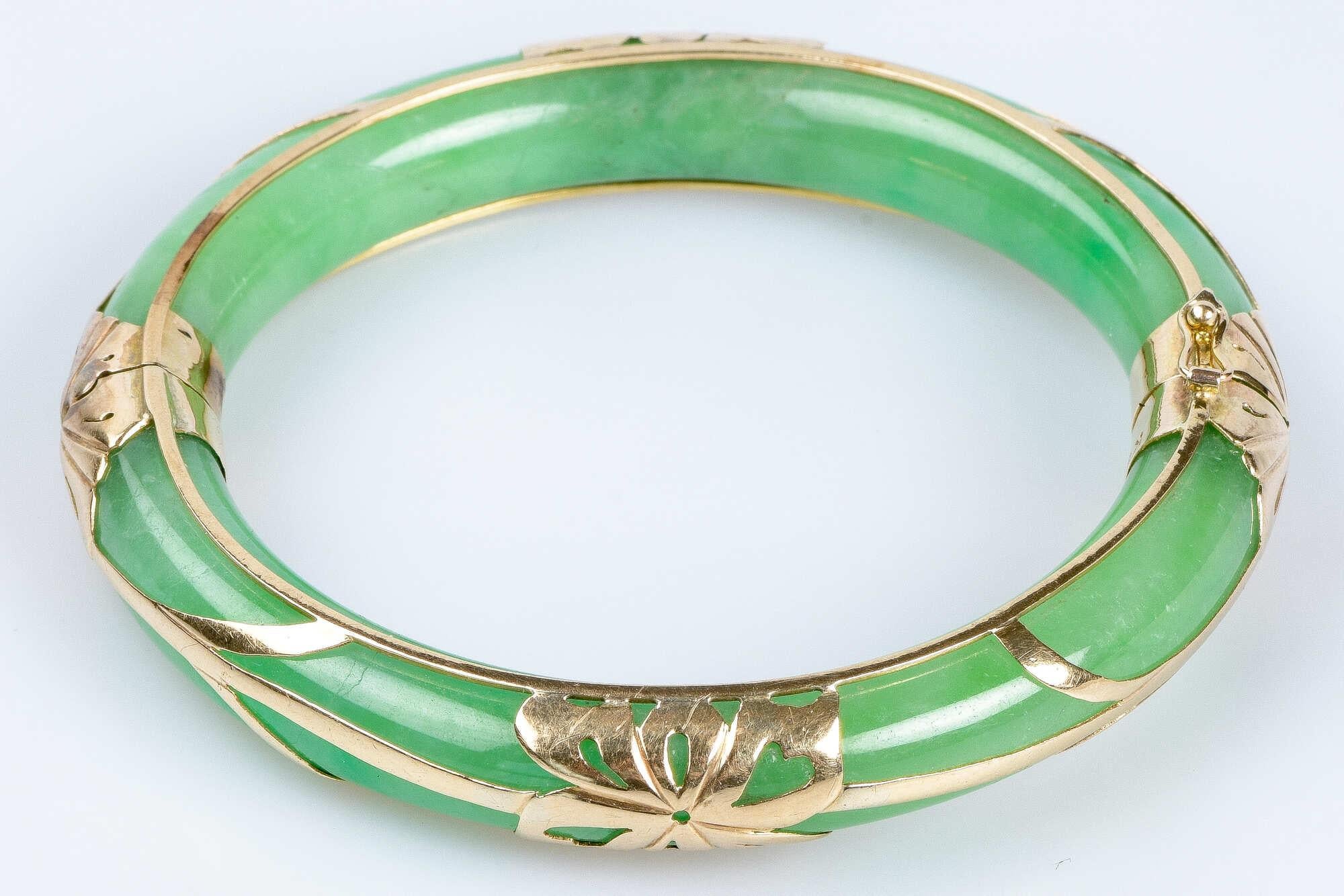 Bracelet rigide en jade avec décorations en or jaune 9 carats. Ce bracelet a une forme incurvée qui épouse le poignet et un fermoir qui permet de le mettre et de le retirer très facilement tout en assurant un maintien sûr et confortable. Le design
