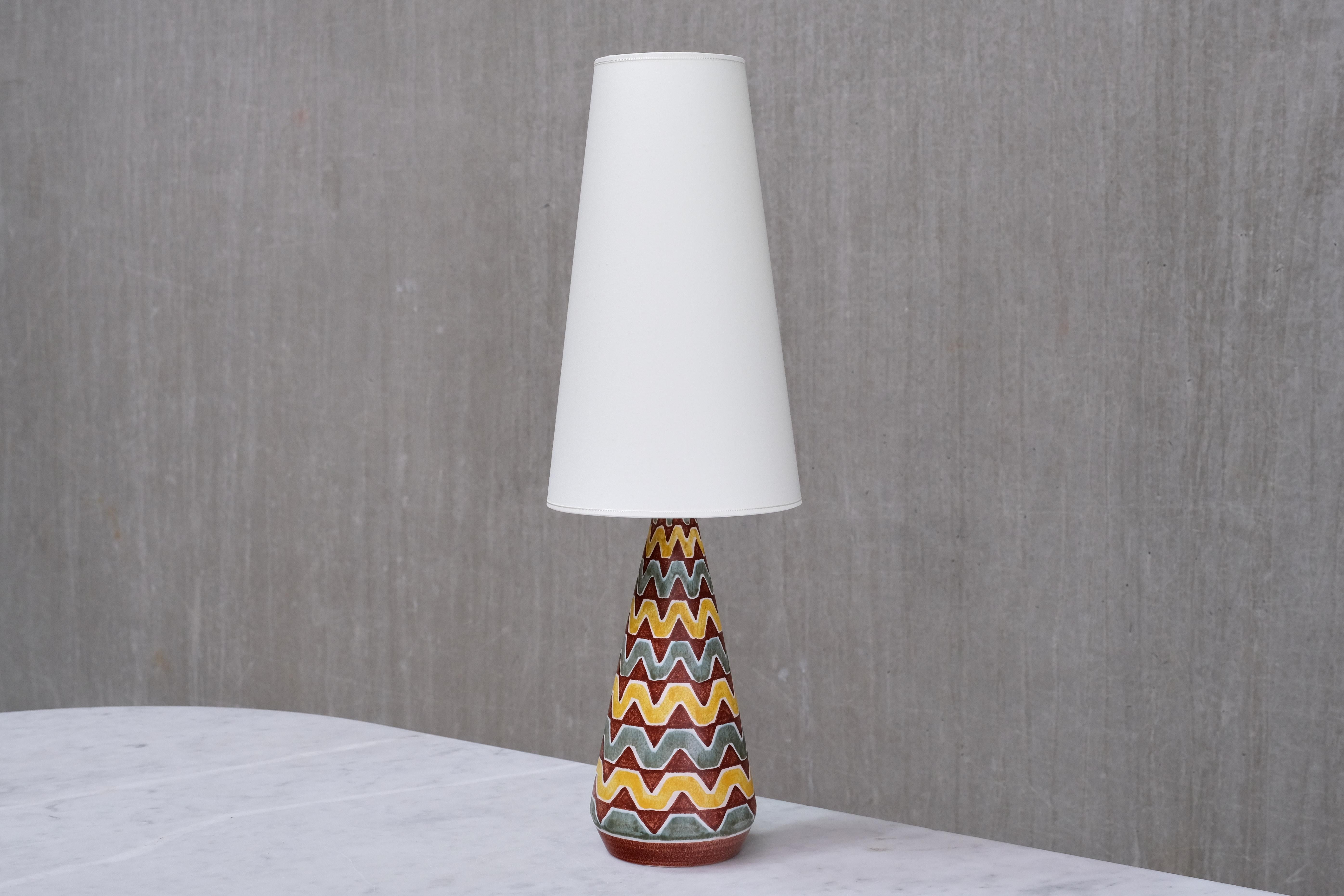 This striking table lamp was designed by Rigmor Nielsen and produced by Søholm Stentøj in Denmark in the 1960s. The lamp is signed with the designer’s initials “RN” and Søholm on the underside of the base.

The design features a tall, tapered