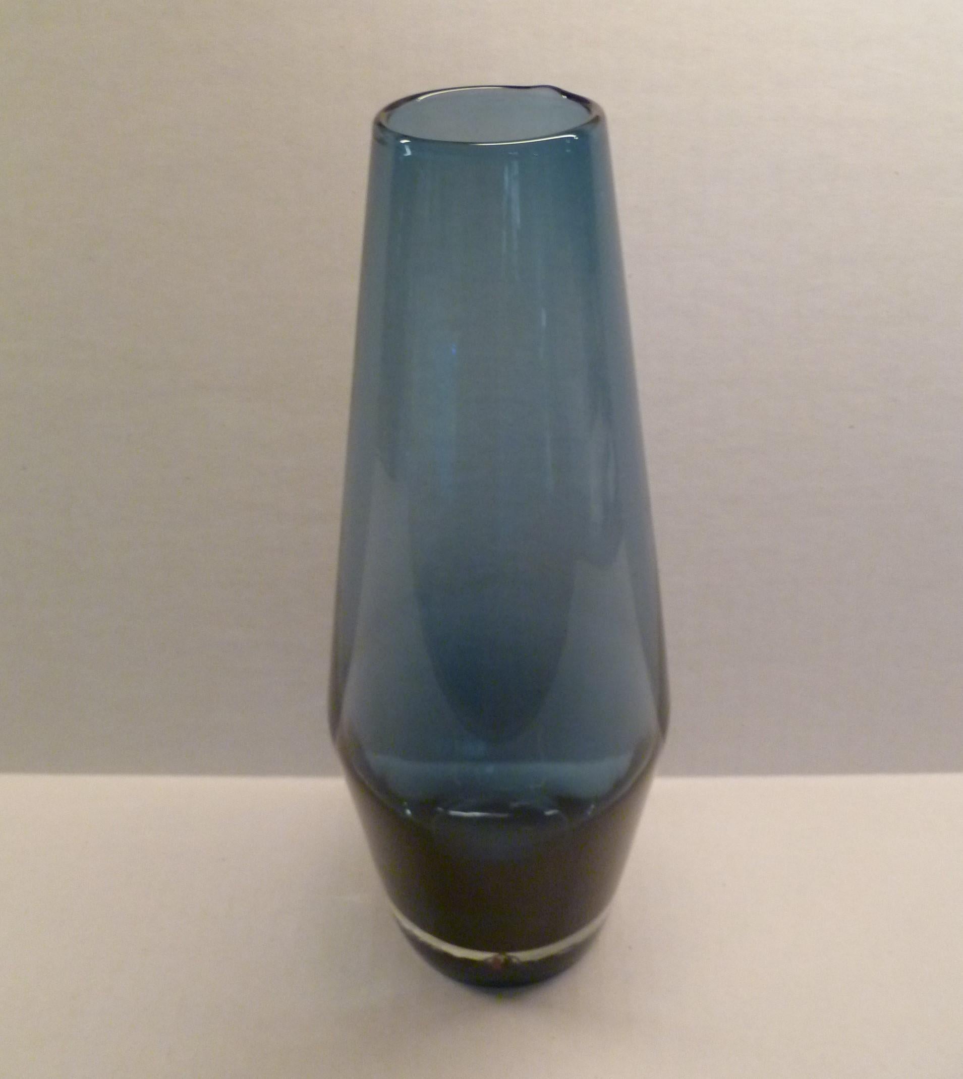 Another selection of a creation by Tamara Aladin, b.1932, for the Finnish glass factory Riihmäki / Riihimäen Lasi Oy. This listing is for the blue-gray colored vase with clear thick base. The base has on its edge the clear triangular Lion Riihimaki