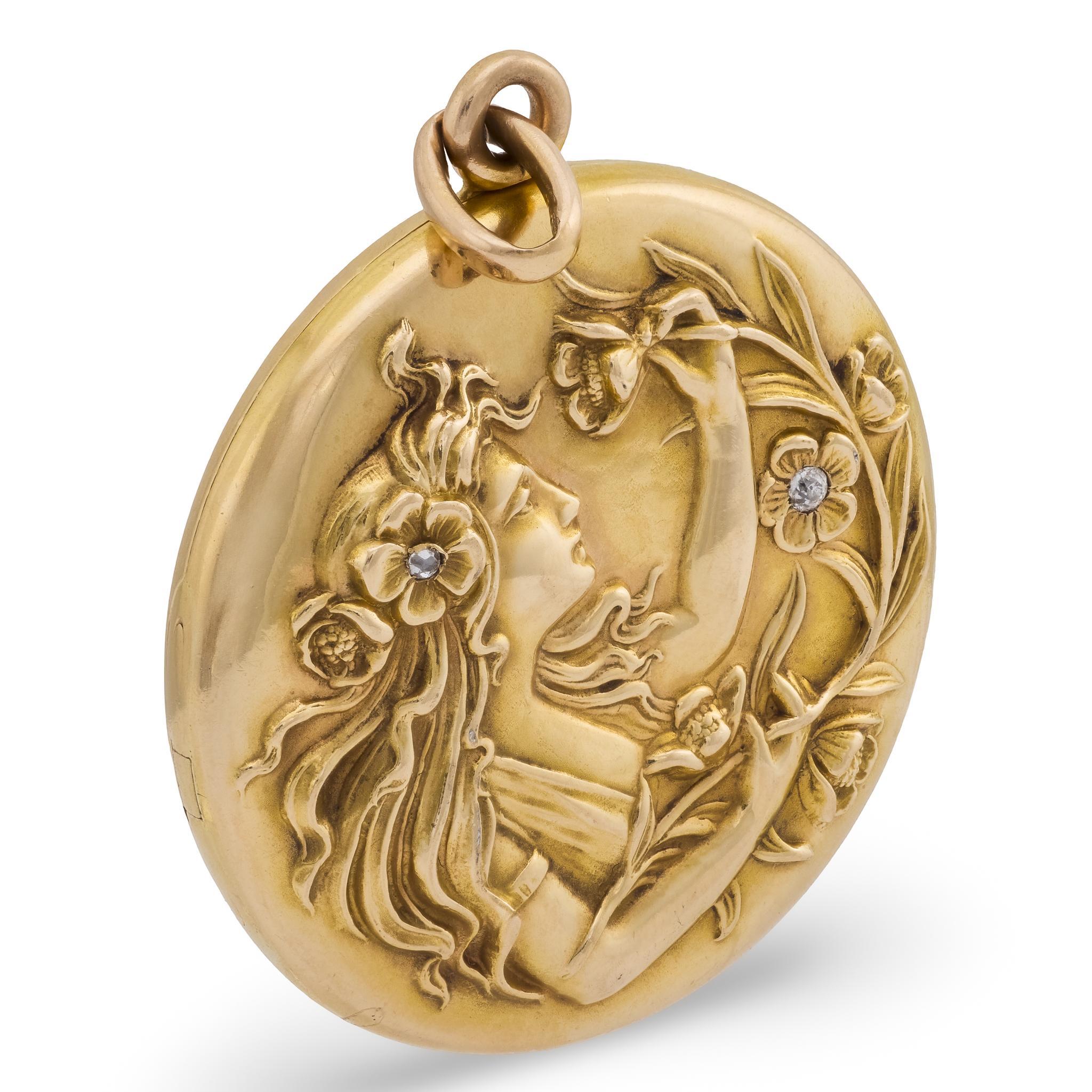 Un magnifique médaillon Riker Bros de l'époque Art Nouveau (ca1910s) ! Réalisé en or jaune 14 carats, ce médaillon circulaire présente sur sa face avant le portrait repoussé d'une belle femme. La femme est représentée avec de longs cheveux flottants