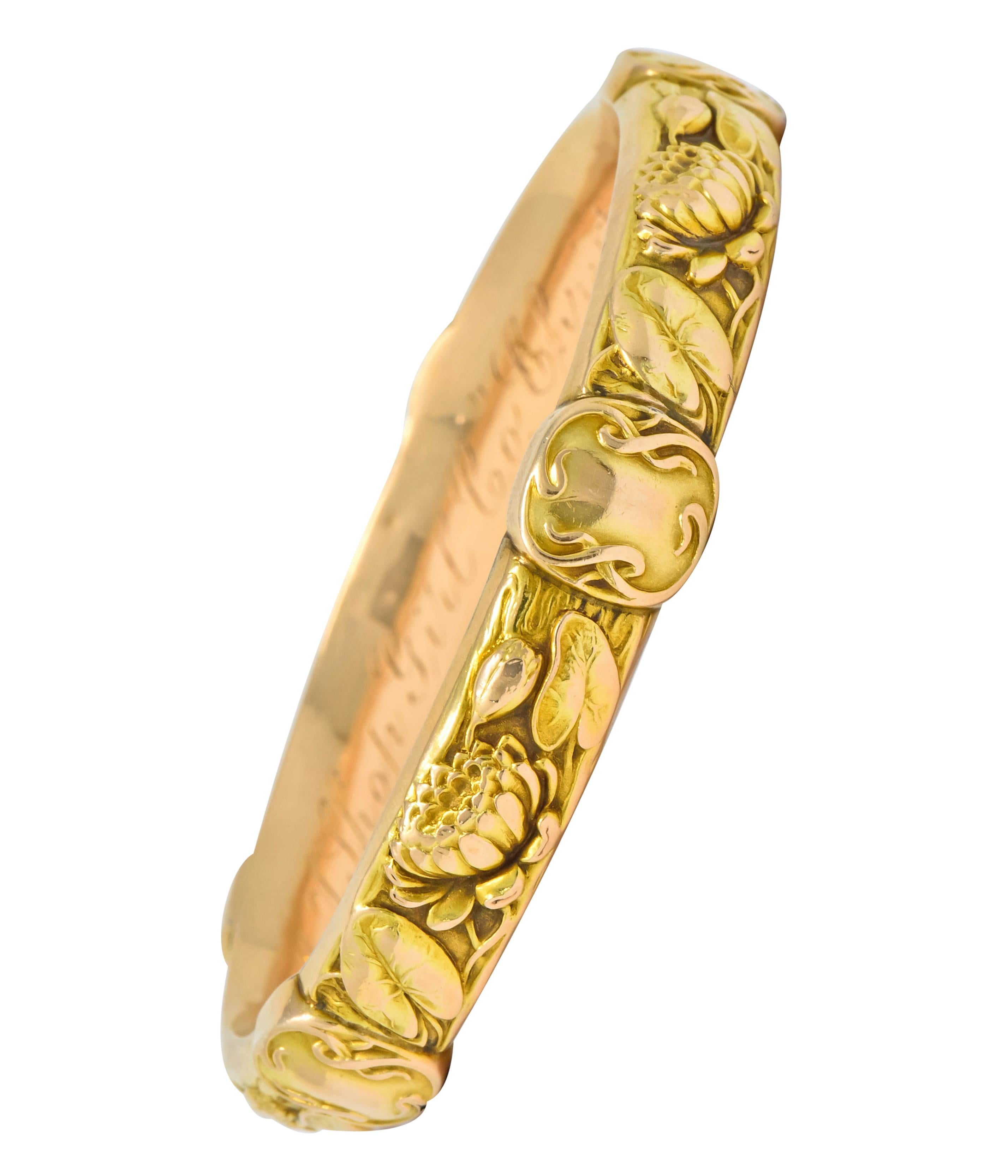 Designed as a wavy edged bangle bracelet depicting a highly rendered lotus and lily pad motif

Accented by five polished cushion stations with stylized ribbon borders

With maker’s mark for Riker Brothers and stamped 14k for 14 karat gold

Circa