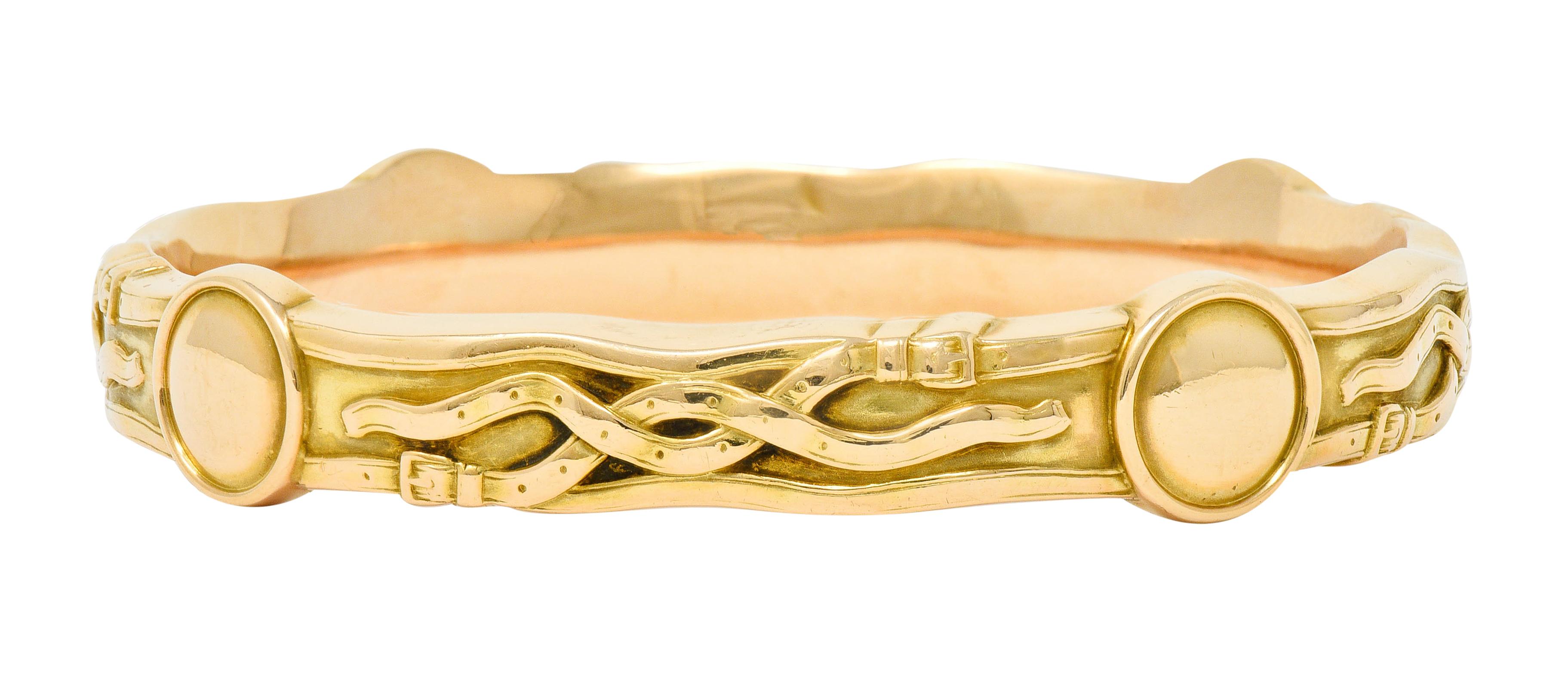 Designed as a wavy edged bangle bracelet featuring four polished circle stations

Decorated throughout by raised and stylized belt-straps

With maker's mark for Riker Brothers and stamped 14k for 14 karat gold

Circa 1900

Width at widest: 1/2
