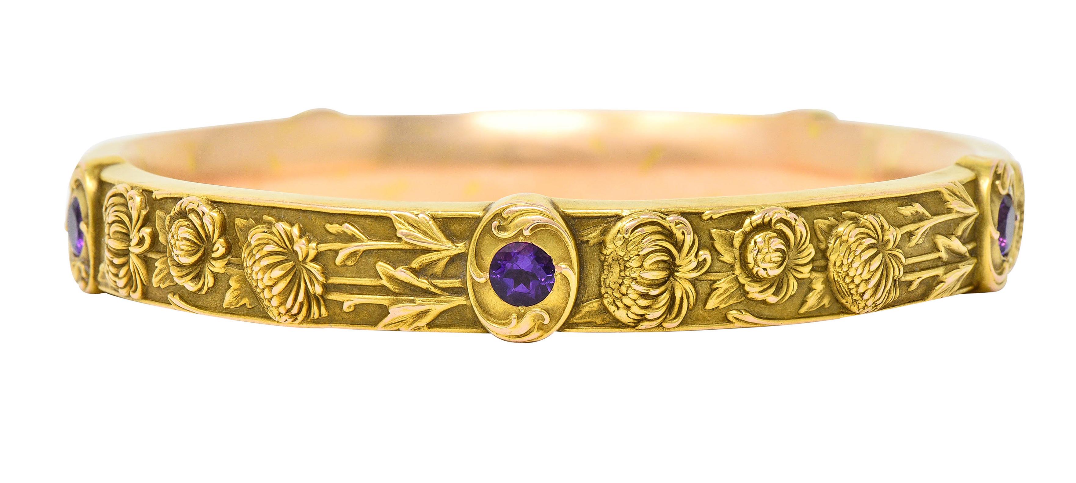 Bangle style bracelet features raised highly rendered chrysanthemums

Accented by five swirled frame stations - each centering a 4.0 mm round cut amethyst

Amethysts are a deeply saturated transparent pinkish purple

Stamped 14k for 14 karat