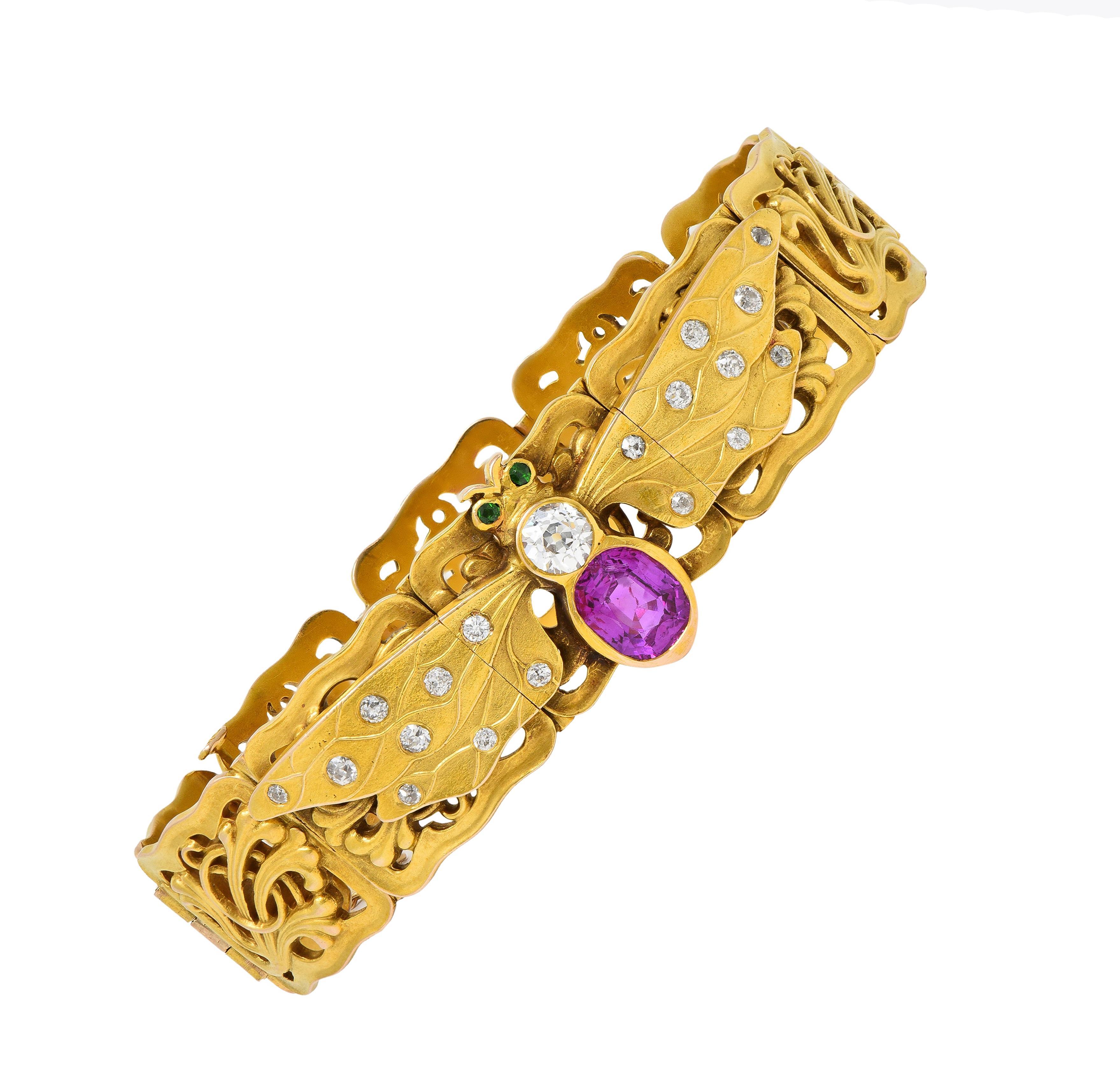 Comprised of hinged rectangular links with a pierced whiplash foliate motif
Centering a stylized bee motif appliqué with a cushion cut ruby body
Weighing approximately 1.70 carats - transparent purplish red in color 
Bezel set below an old European