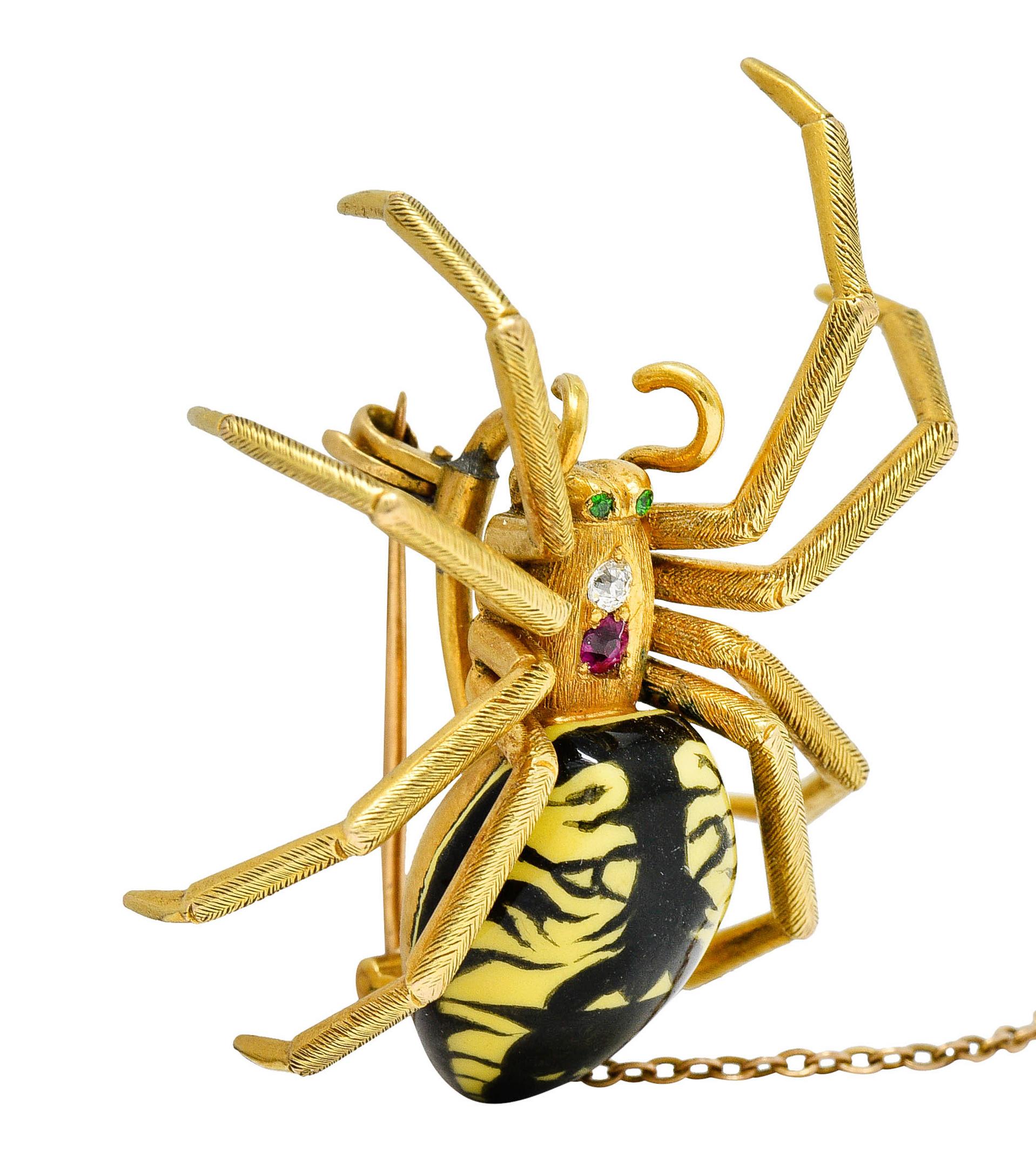 Brooch is designed as a highly rendered spider with spindly legs

Its abdomen is glossed with vibrant black and yellow enamel - exhibiting minor loss

Its thorax is bead set with a diamond and a ruby - weighing in total approximately 0.10