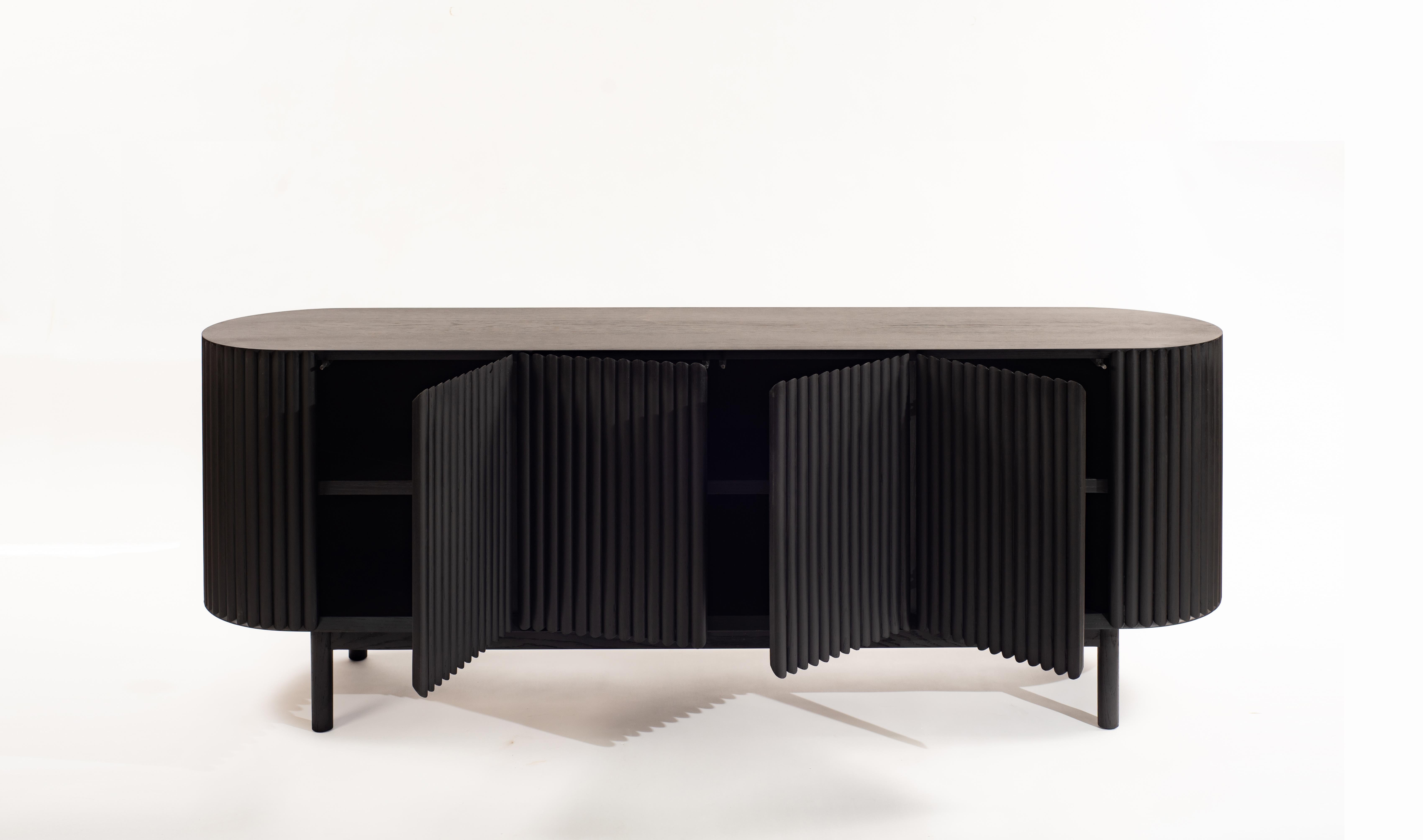 Between the sculpture and the functionality of the object, the RIMA credenza is inspired by the dynamism and the cadence of a poem, drawing all the attention to the wooden slats that are repeated one after the other to form a texture that embraces