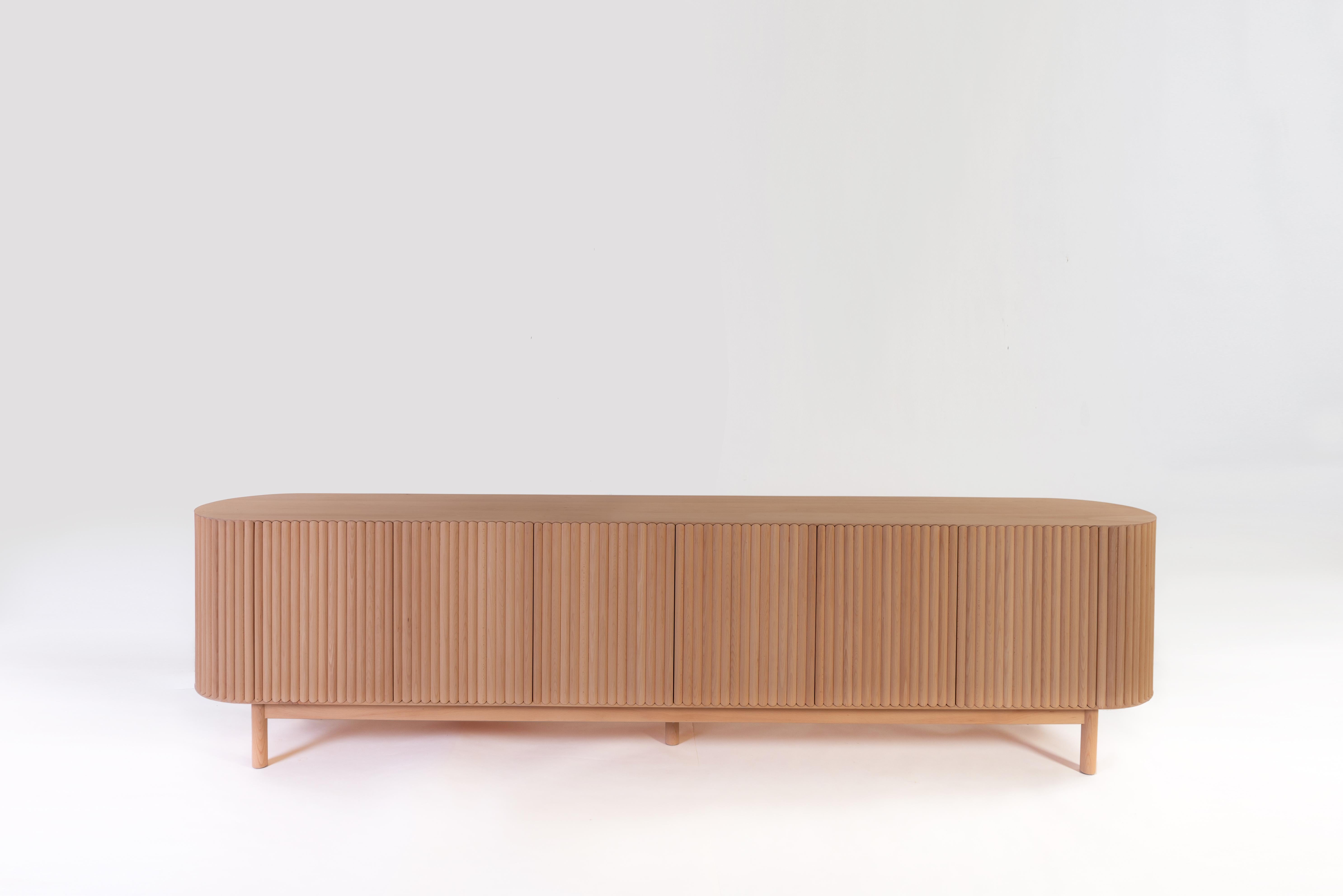 Between the sculpture and the functionality of the object, the RIMA credenza is inspired by the dynamism and the cadence of a poem, drawing all the attention to the wooden slats that are repeated one after the other to form a texture that embraces