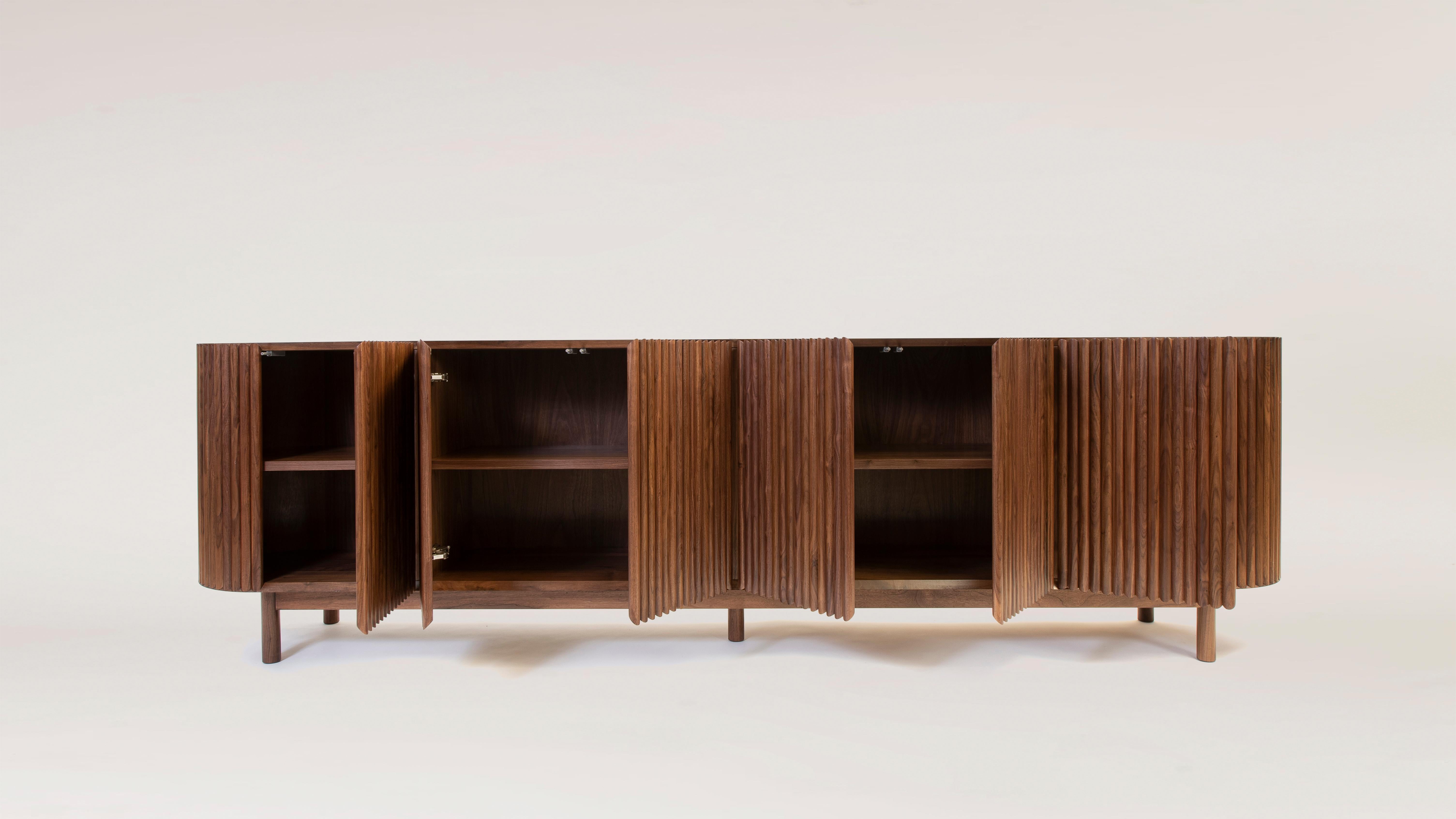 Between the sculpture and the functionality of the object, the RIMA credenza is inspired by the dynamism and the cadence of a poem, drawing all the attention to the wooden slats that are repeated one after the other to form a texture that embraces