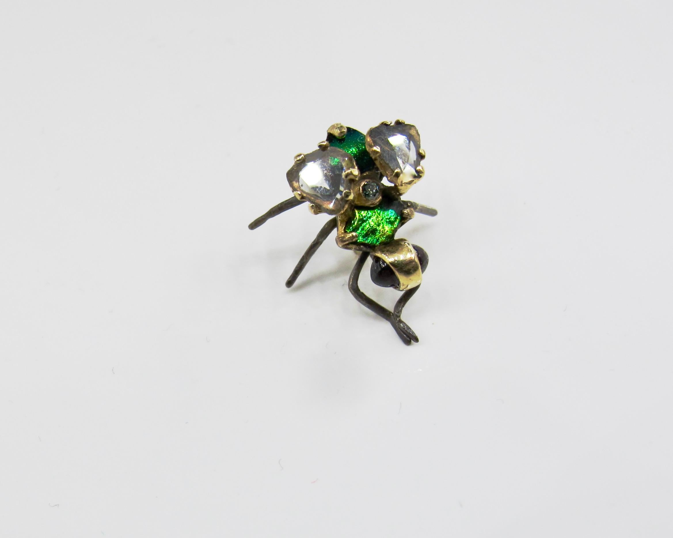 RIMA JEWELS hyperrealistic fly stud earring features an 18k gold body with oxidized silver legs. The common house fly's wings are comprised of diamond slices and the upper body is made of elytra beetle wing doublets. Glowing garnet cabochons are set