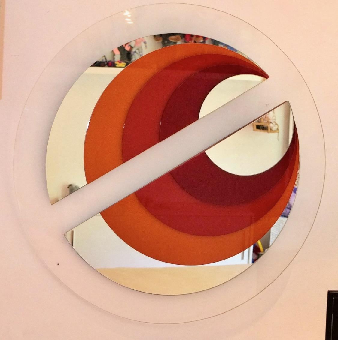 Space age custom round mirror  in the style of Rimadesio consisting of concentric discs of alternating mirrored glass and colored arylic in the red color spectrum. Engraved signature 