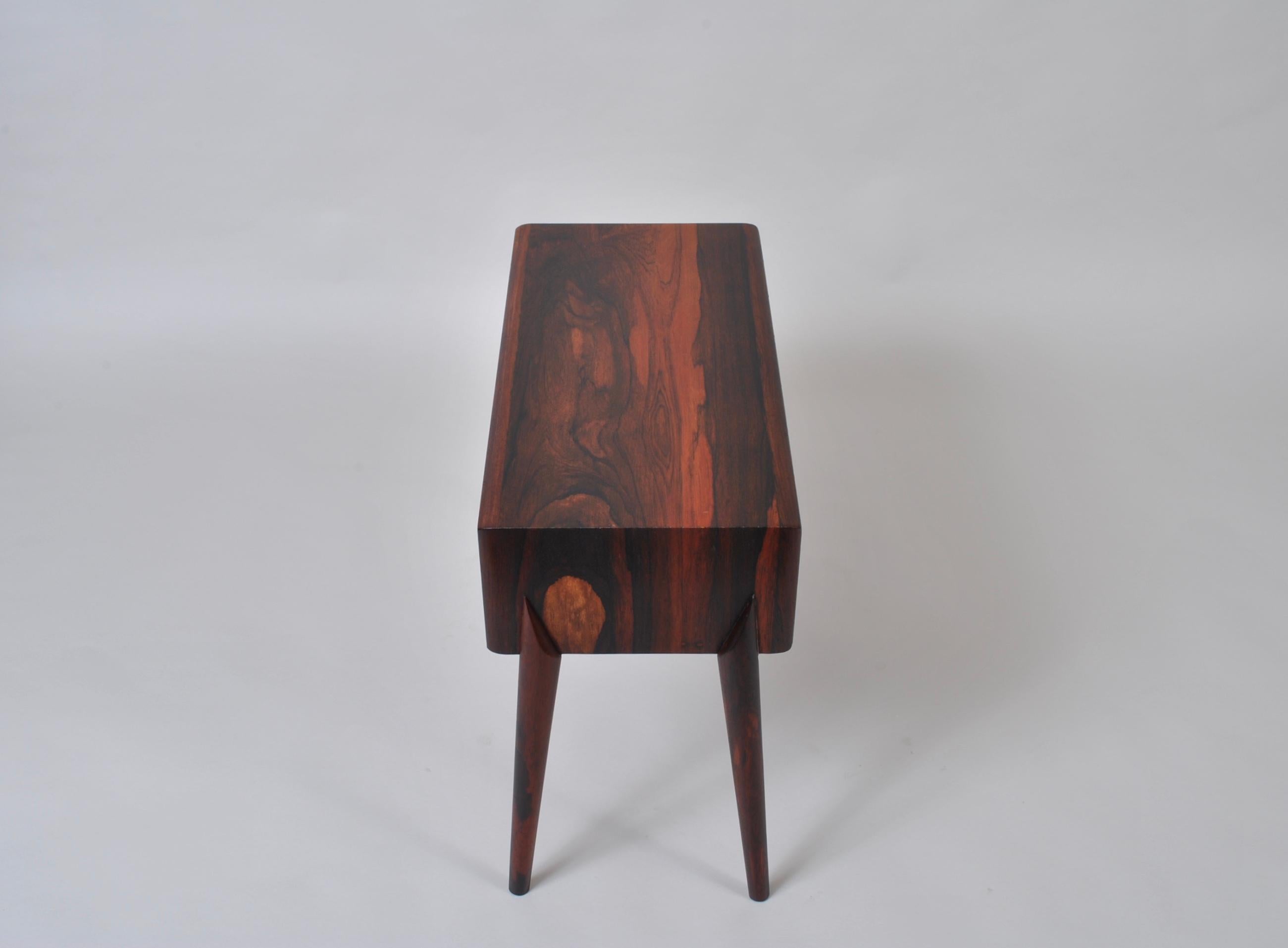 Utterly charming and striking little chest of drawers or side/end table by Rimbert Sandholdt for Glas & Tra Hovmantorp, Sweden, circa 1960. Incredible use of the rosewood veneers and beautifully sharp shaped legs.