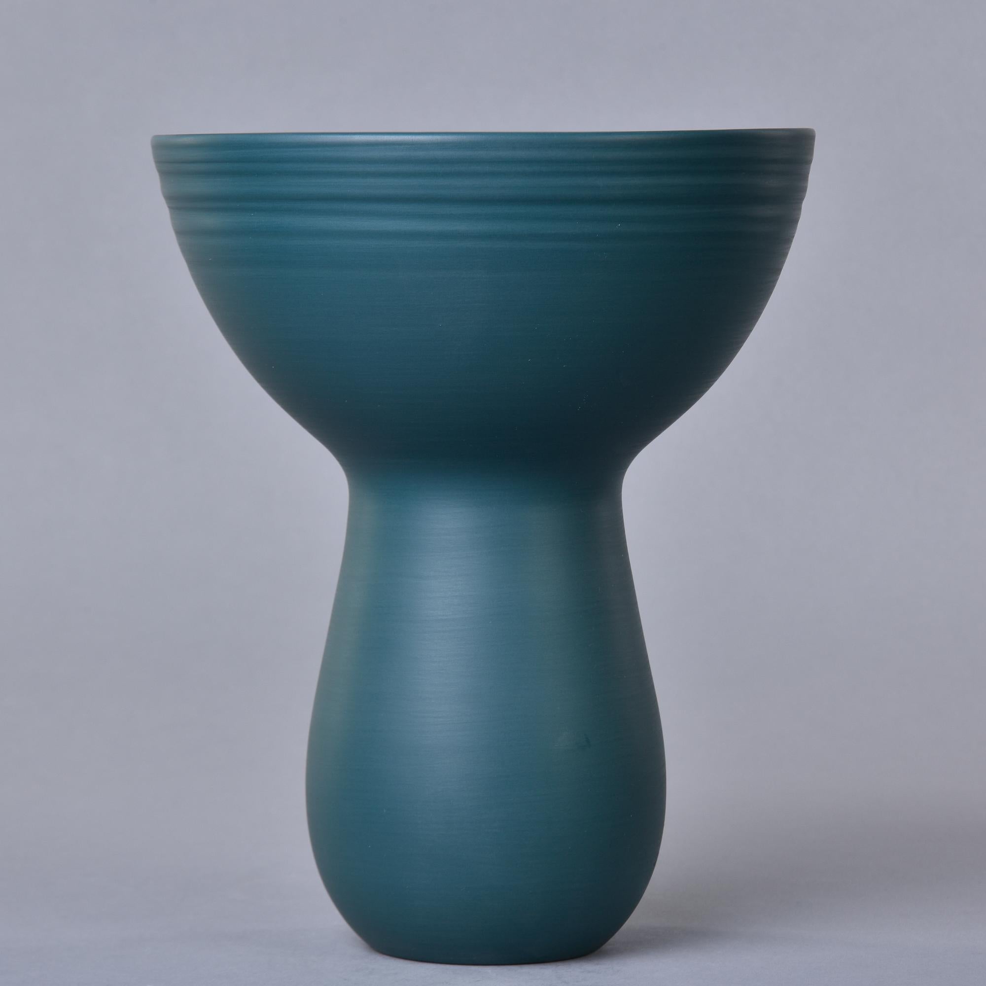 New and made in Italy by Rina Menardi, this bouquet vase stands 10” tall. This finely crafted pottery has a saturated, matte teal green glaze inside and out, thin walls, and a sculptural shape with a narrow, rounded base and bowl-like rim. Signed by