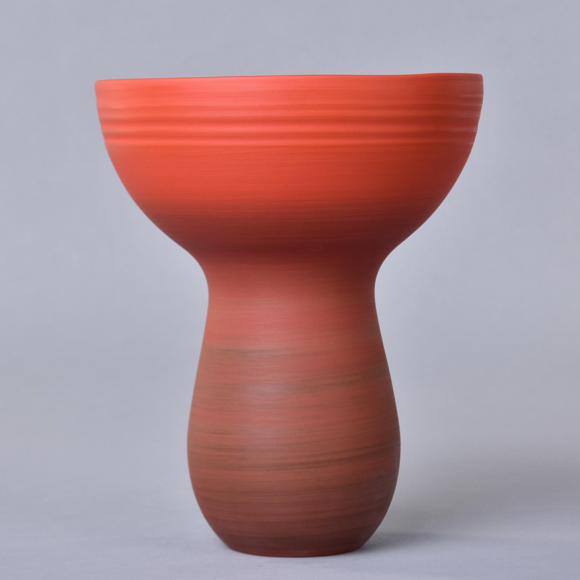 New and made in Italy by Rina Menardi, this bouquet vase stands 10” tall. This is finely crafted pottery has a dark orange-red ombre glaze inside and out, thin walls, and a sculptural shape with a narrow, rounded base and bowl-like rim. Signed by