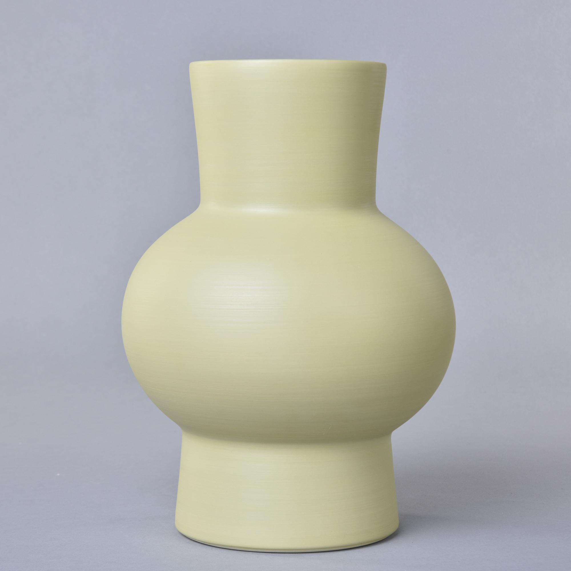 New and made in Italy by Rina Menardi, this thin-walled vase stands over 12” high and has,a pleasing shape. The pale pistachio colored glaze has a contrasting dark washed interior. Signed on underside of base. New with no flaws found. Other colors,
