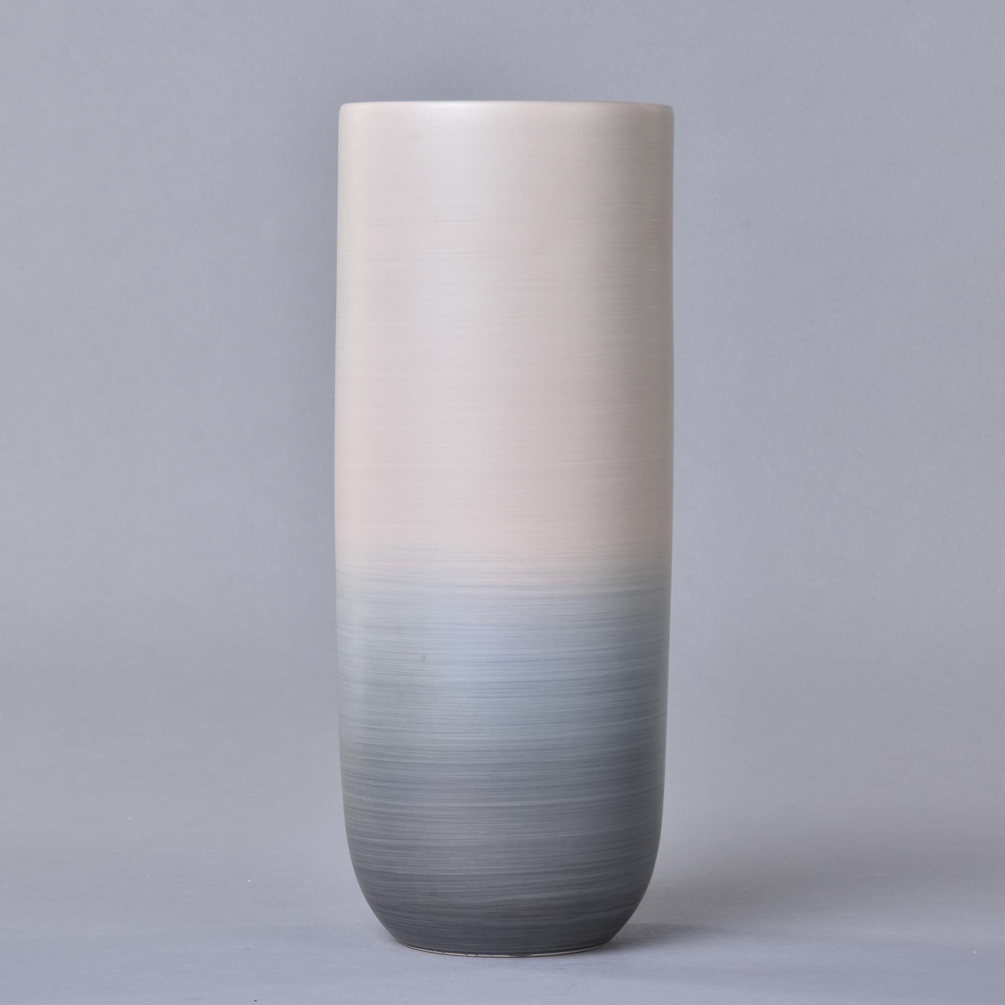 New and hand made in Italy by Rina Menardi, this vase stands over 12” tall and has an ombre style glaze in shades of beige and blue/gray. Streamlined shape with thin, glazed porcelain walls and a contrasting dark glaze on the inside. Signed by the