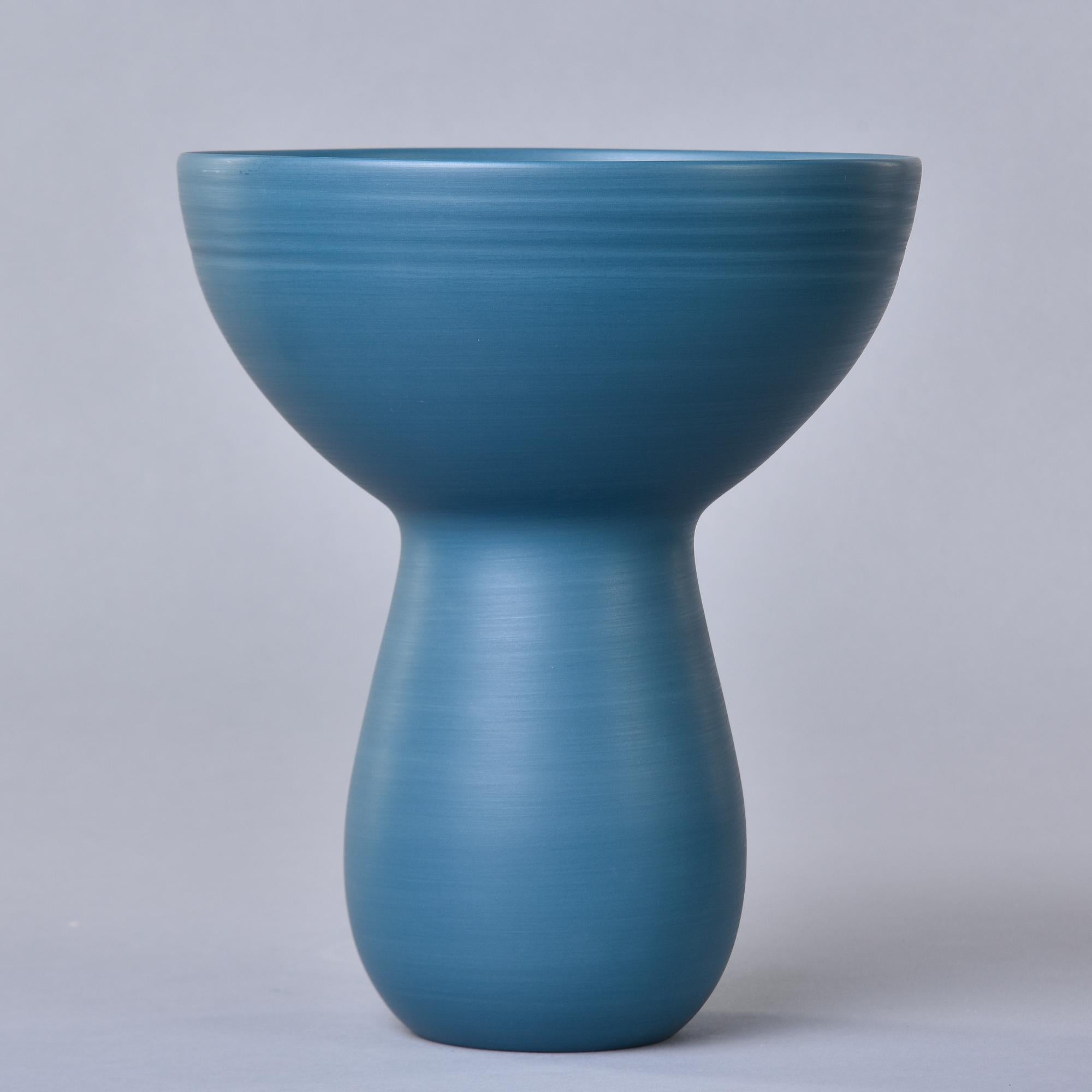 New and made in Italy by Rina Menardi, this bouquet vase stands 10” tall. This is finely crafted pottery has a saturated teal blue glaze inside and out, thin walls, and a sculptural shape with a narrow, rounded base and bowl-like rim. Signed by