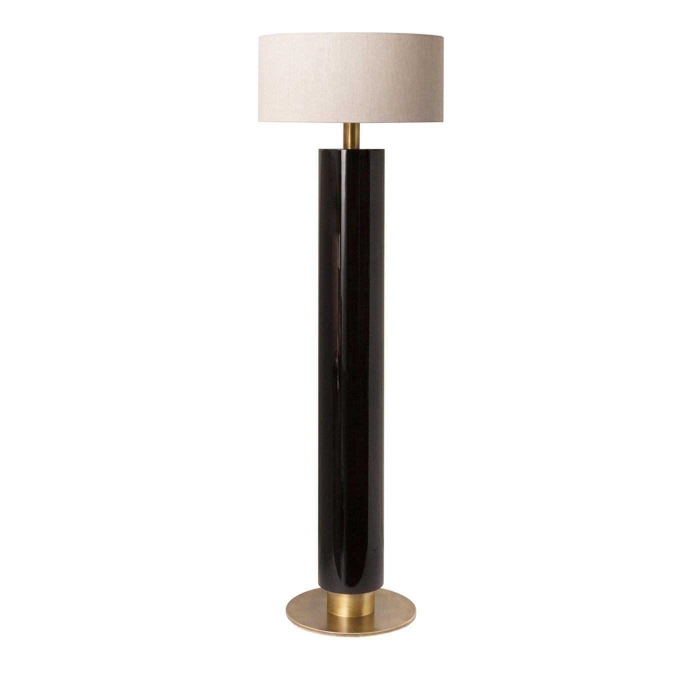 En nogal con acabado brillante oscuro, detalles en latón bruñido y pantalla de tambor, la Lámpara de pie Rindo es un complemento chic para salones contemporáneos. Con su atractivo atemporal, la lámpara se integra fácilmente en cualquier contexto de