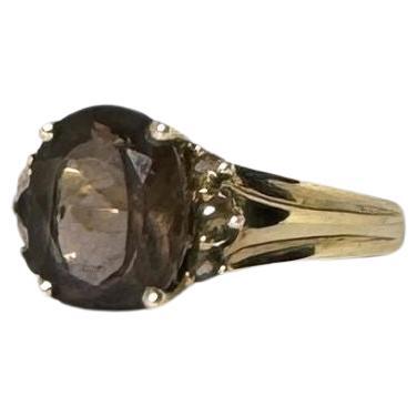 This ring will have you looking chic in no time. This oval cut smoky quartz is an absolute eye-catcher and is joined on the shoulders by 3 small smoky quartzes (on each side) in a chaton setting. This vintage ring is for those who love to make a