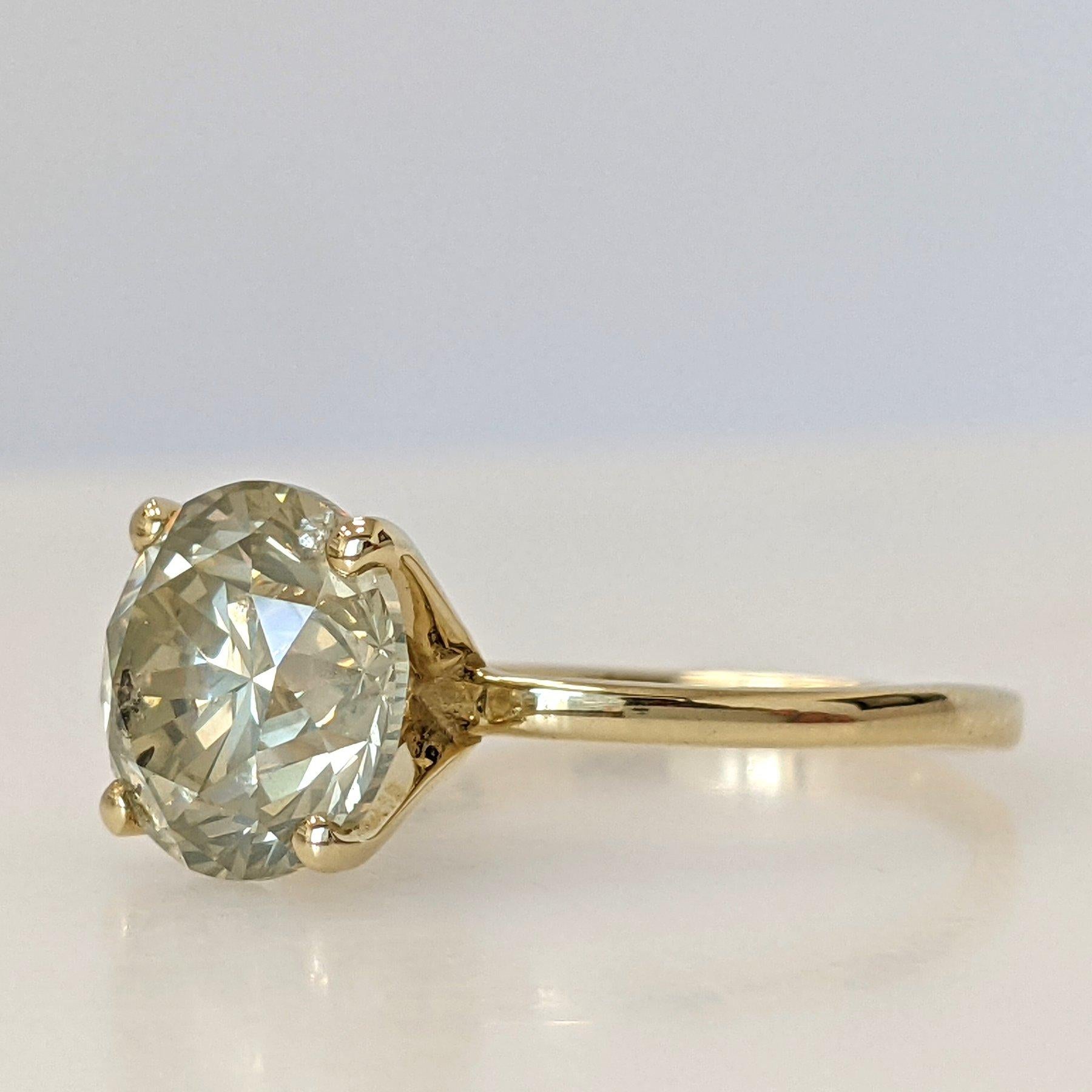 Cette magnifique bague présente un design unique avec des diamants naturels, totalisant 3,11 carats, sertis dans de l'or jaune 14kt lustré. L'anneau en or jaune ajoute une touche de sophistication au design, faisant de cette bague un accessoire