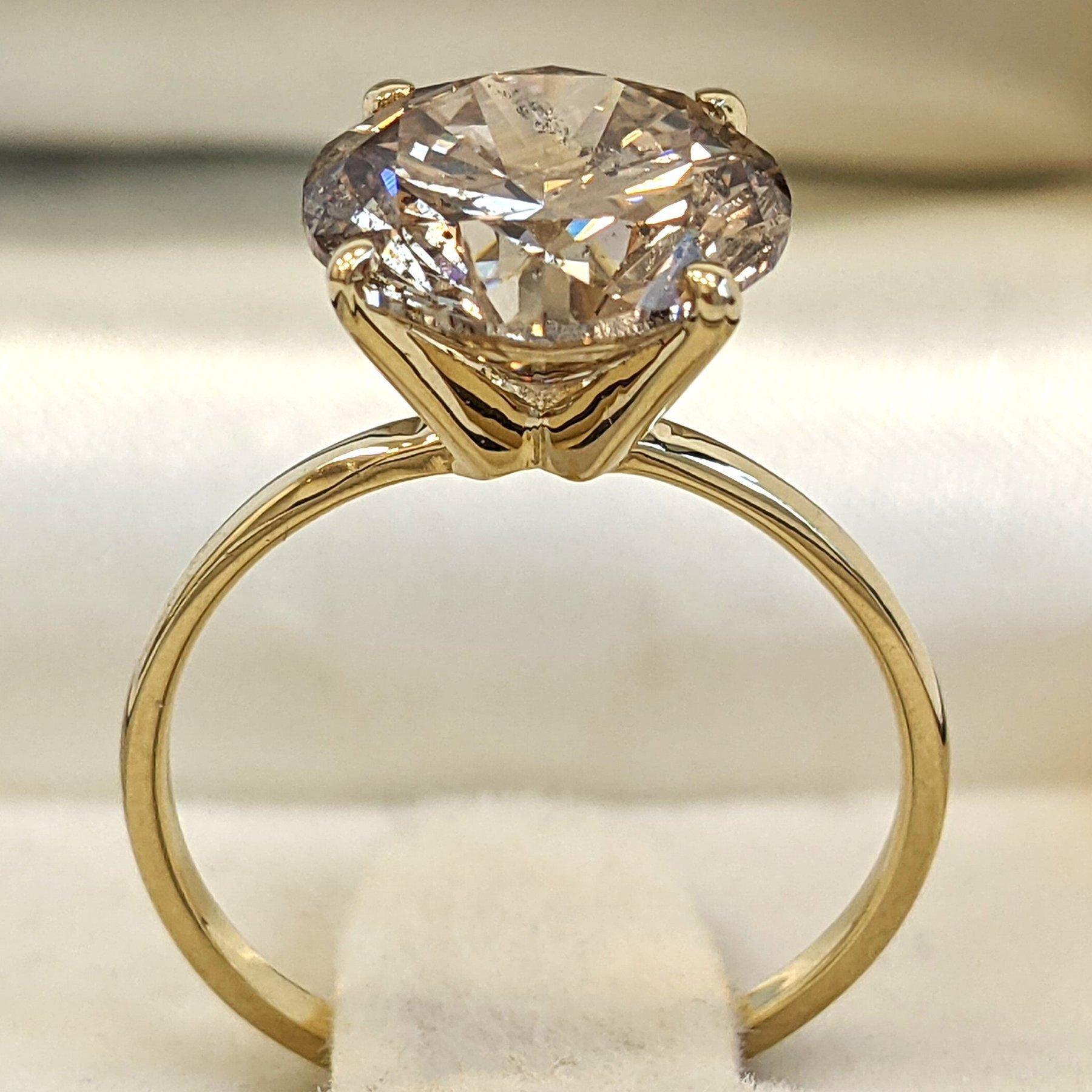 Dieser atemberaubende Ring zeichnet sich durch ein einzigartiges Design mit natürlichen Diamanten von insgesamt 4,01 Karat aus, die in glänzendes 14-karätiges Gelbgold gefasst sind. Das Gelbgoldband verleiht dem Design einen Hauch von Raffinesse und