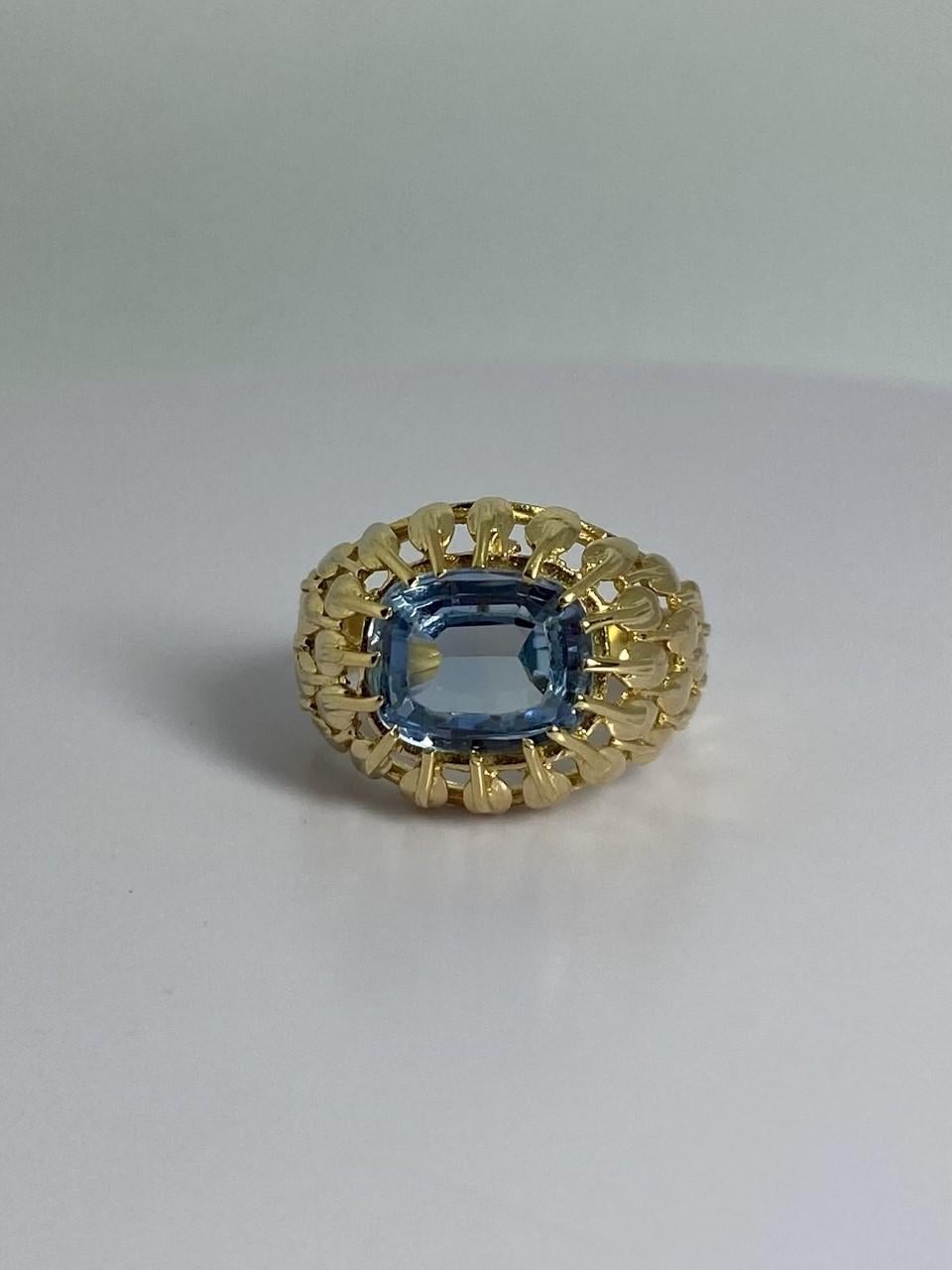 A ring to make your appearance! This pre-loved jewel is made 18 carat yellow gold with a blue spinel. The oval blue spinel is emerald facetted.  Look close at the pictures and see the detailed crafted band of this ring. If you need a re-size, just