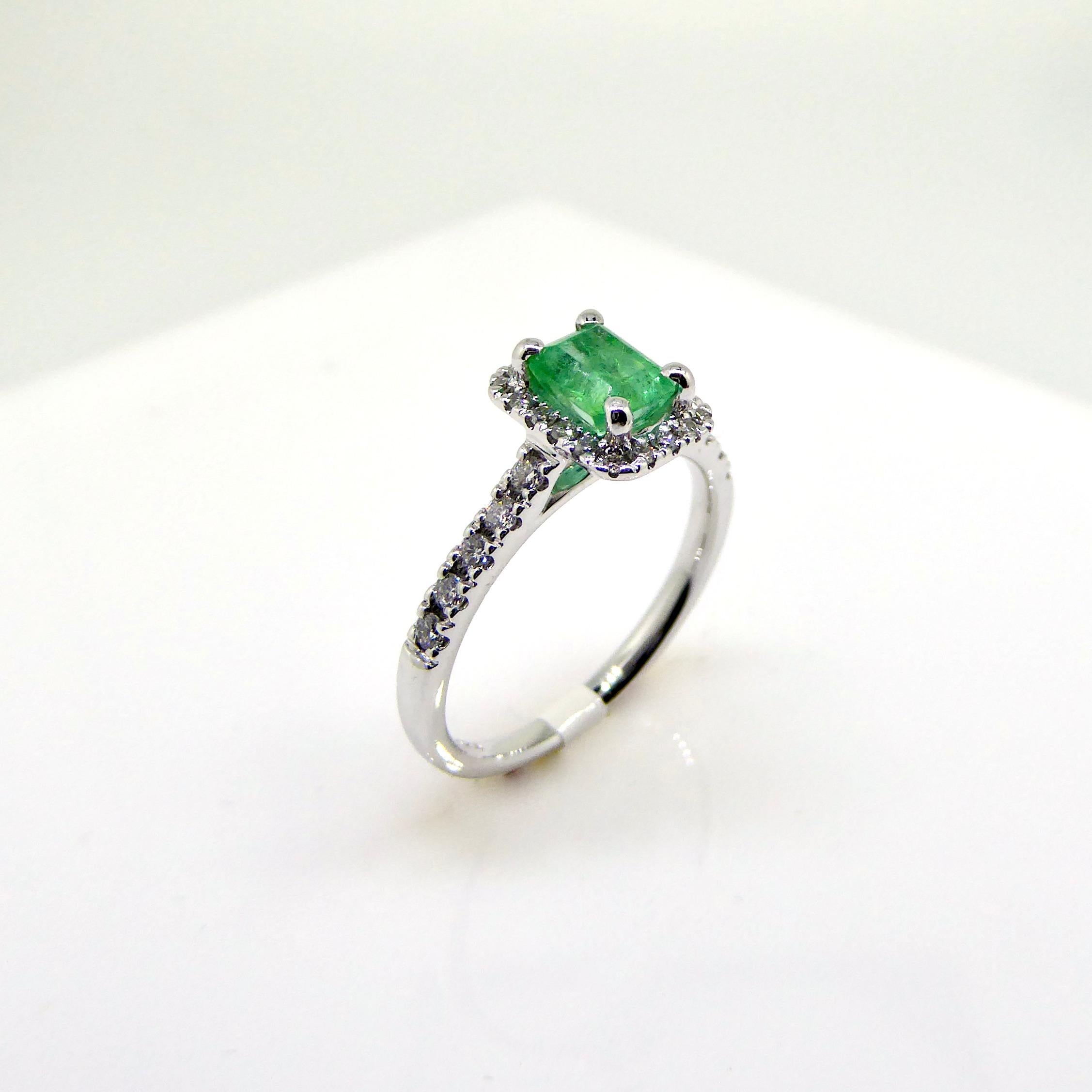 18 carat white gold cluster ring, set with 28 diamonds, brilliant cut, total 0,29 carat. Emerald in emerald cut, Colombia Emerald, 0,70 crt. The Musomine is one of the most famous mines for emeralds in Colombia. A bright fresh geen color. Complete