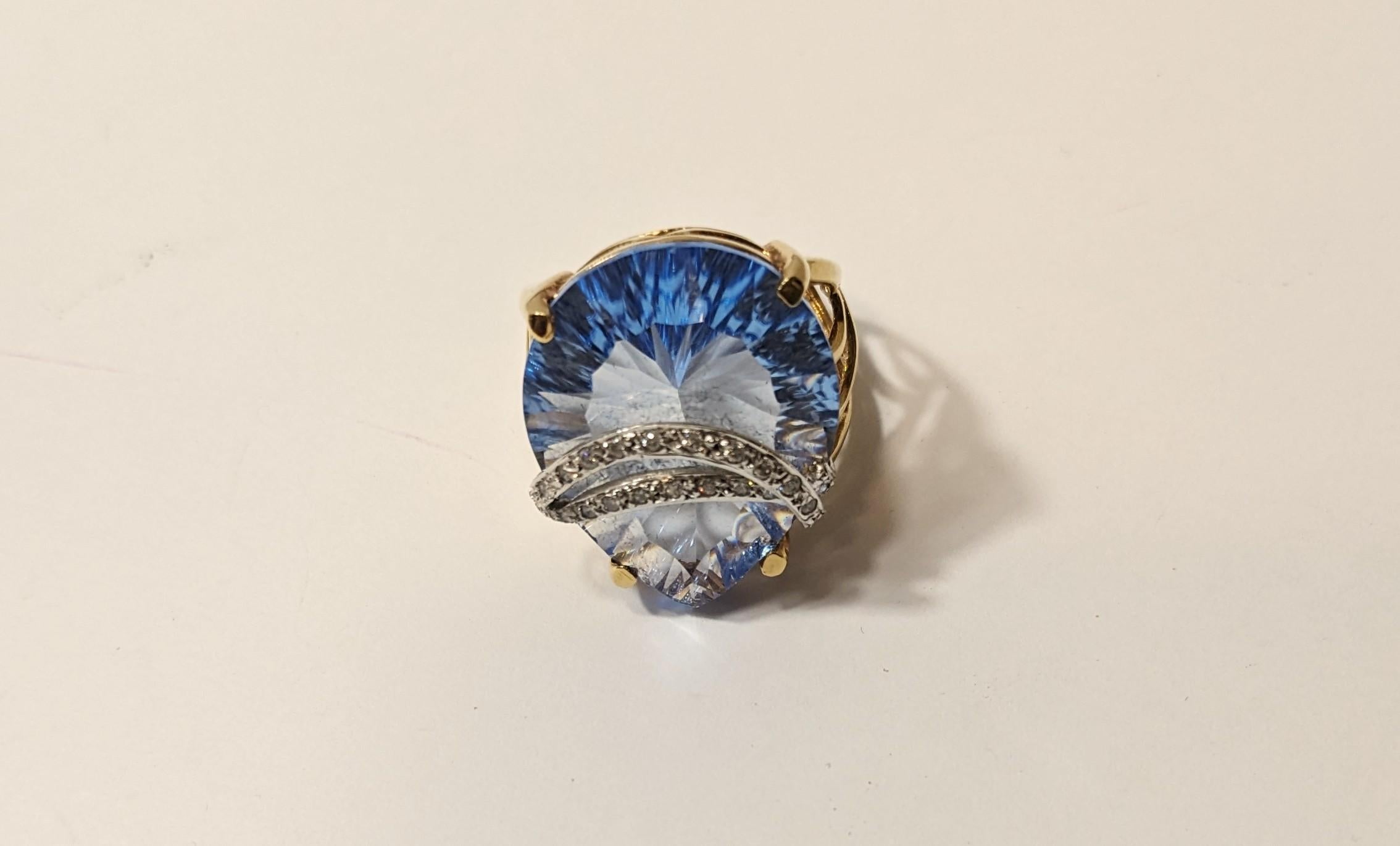 Ring 18K Yellow Gold with White Diamonds and Oval Blue Quartz
Yellow Gold 18K. And Pear Shape Blue Topaz 12ct
and .3ct diamonds 
Weight 9,2 gr.
Size 14
IRAMA PRADERA the creative director of design and estate department has a 