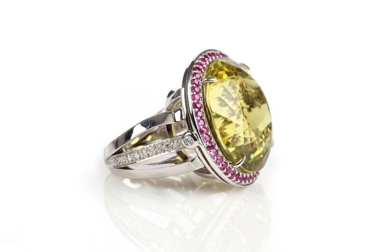Anillo de cóctel en banda de oro de 18 quilates adornado con diamantes y zafiros rosas, con un citrino limón como piedra central. Esta combinación de piedras preciosas crea una pieza de joyería vibrante y elegante.

Anillo de Cóctel de Oro Blanco de