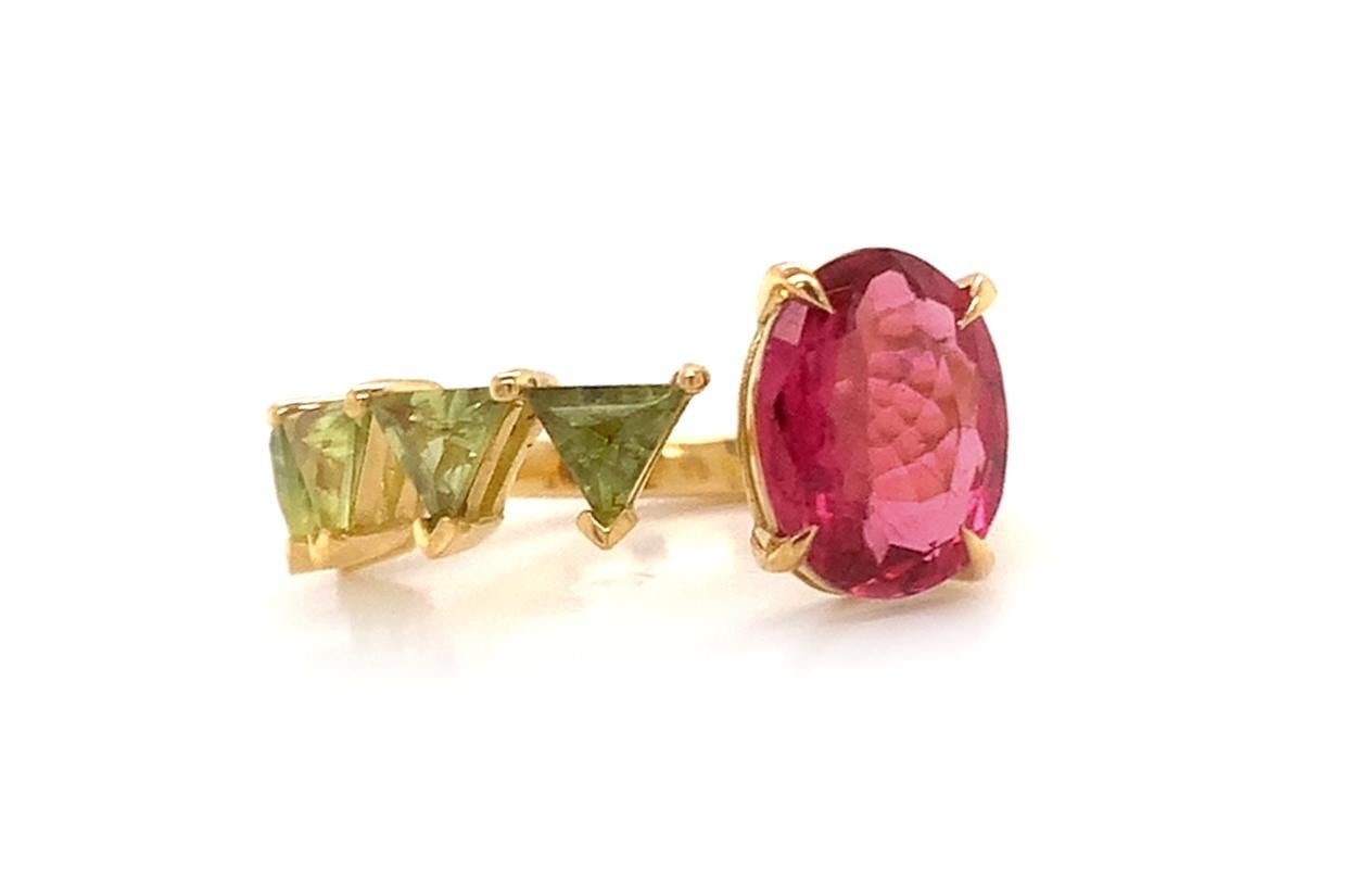 An exquisite masterpiece of jewelry craftmanship, this floating ring is a mesmerizing blend of luxury and elegance. Crafted from lustrous 18kt yellow gold, it delicately cradles a resplendent green sapphires trillions and captivating oval Rubellite,