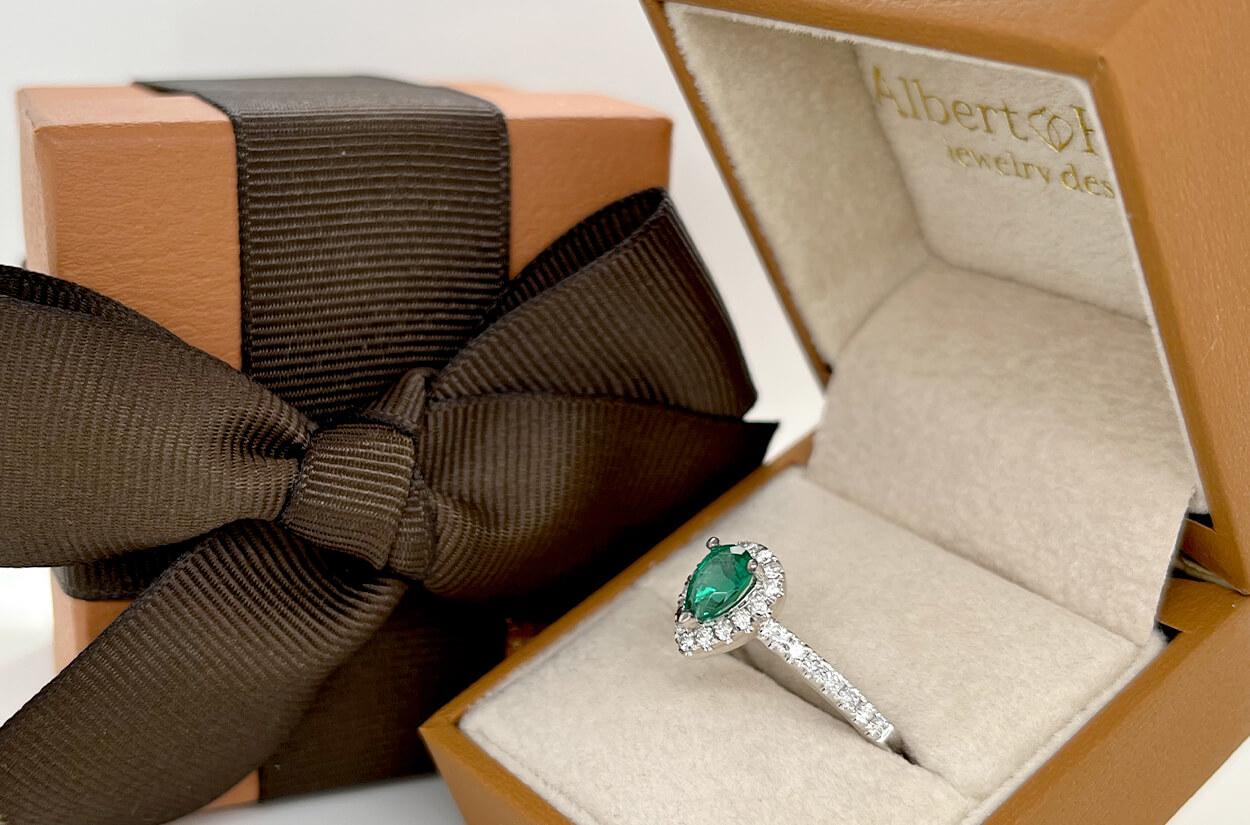This handcrafted 18kt white gold ring features a 0.60-carat pear-shaped emerald, surrounded by 29 round diamonds totaling 0.42 carats. Made in the USA and sized at 6.5, it's a unique expression of elegance and love.