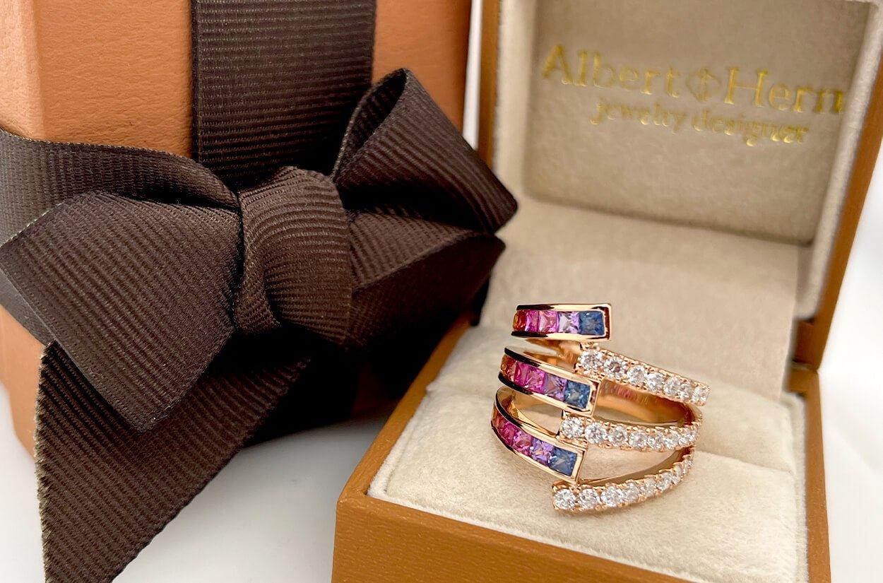 Adorn your finger with this exquisite beaty of this 18kt rose gold multi-row ring, gracefully showcasing a harmonious blend of colorful sapphires and dazzling diamonds. The intertwining rows create a captivating dance of light and color, making it a