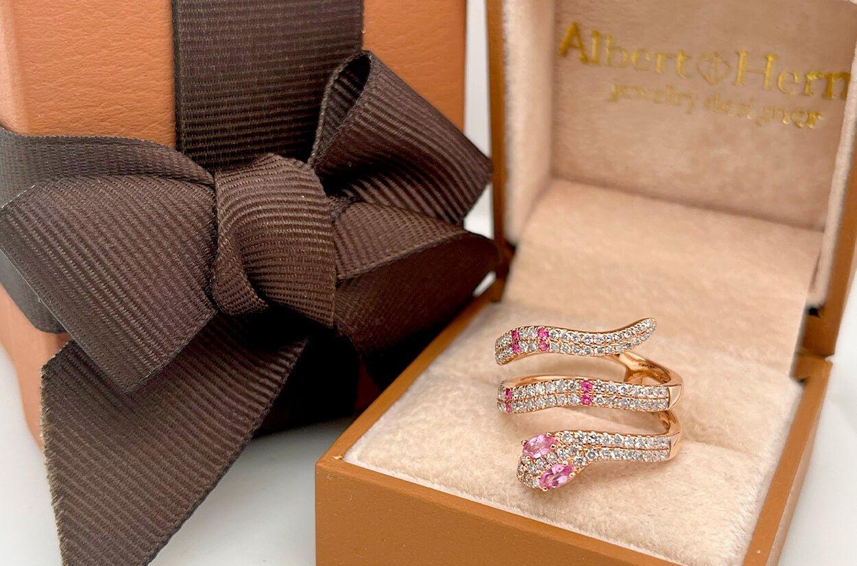 This exquisite serpent-shaped ring is crafted from lustrous 18kt rose gold, adorned with a captivating array of pink sapphires and diamonds. Its sinuous design gracefully coils around your finger, making it a symbol of timeless beauty and