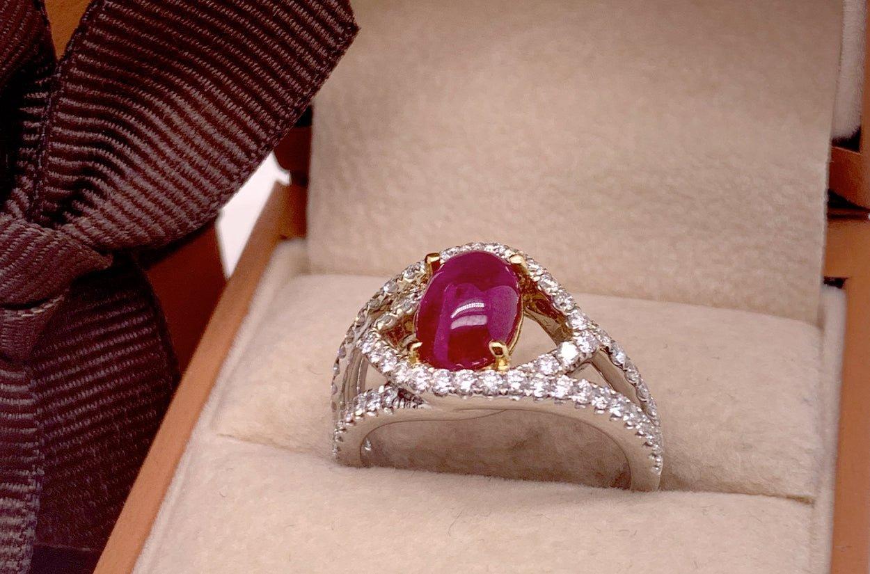 A ring made of 18kt gold with a center ruby cabochon of extra quality, surrounded by round diamonds, sounds like a stunning and luxurious piece of jewelry. It would likely be a beautiful and eye-catching accessory. If you have any specific questions