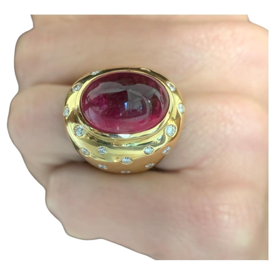 Ring 18kt Yellow gold 22 grams. Center Rubilite Cabochon 15,3 carats and Body Enhance by diamonds 1,05 carats. 

Size 6.