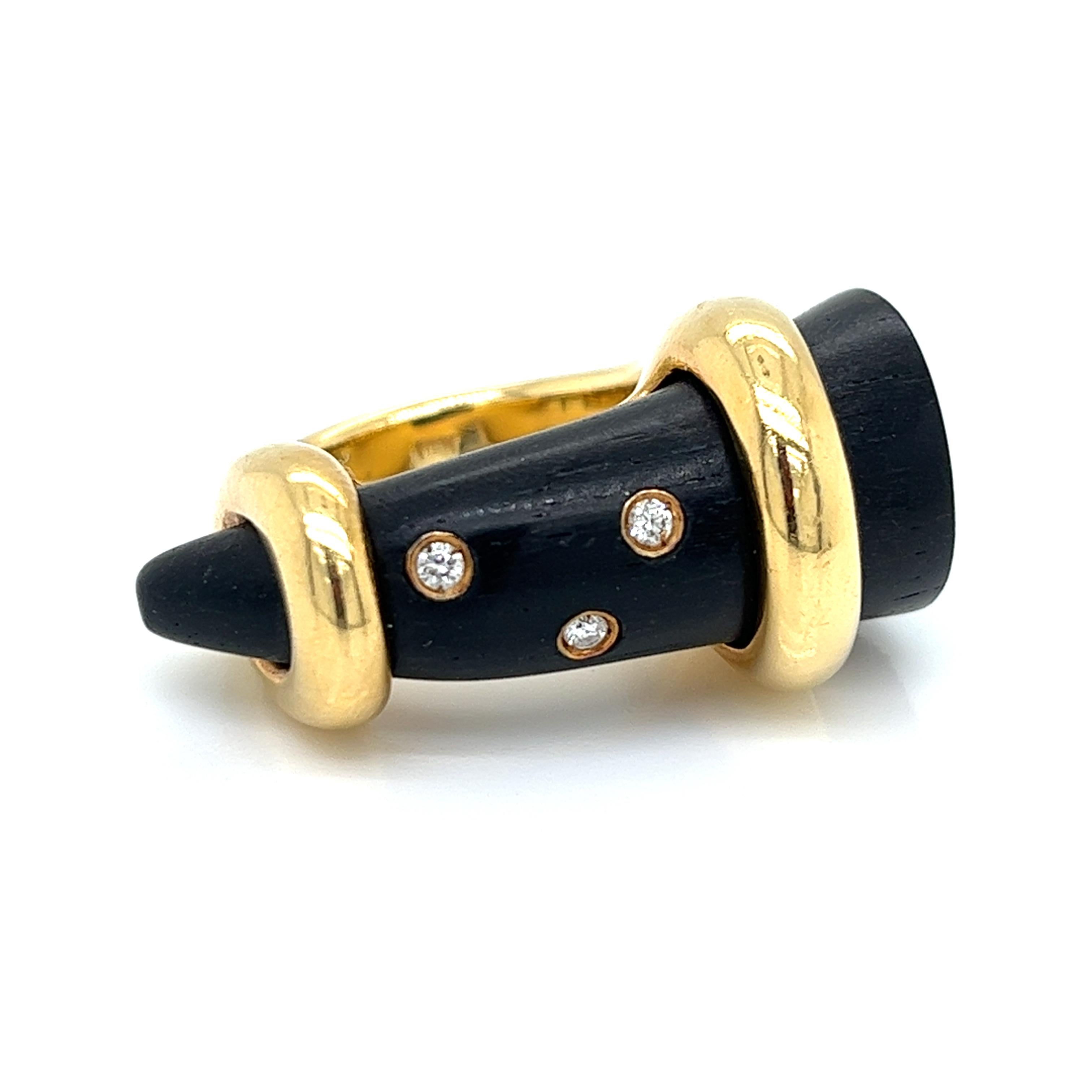  OROMALIA - A diamond and Ebony wood dress ring 
designed as a wood claw sliding into a pavé set diamond loop on one side of the band, signed Oromalia and marked to shank 
18kt gold
15.50 grs 
3 Natural Diamonds 0.06 carats 