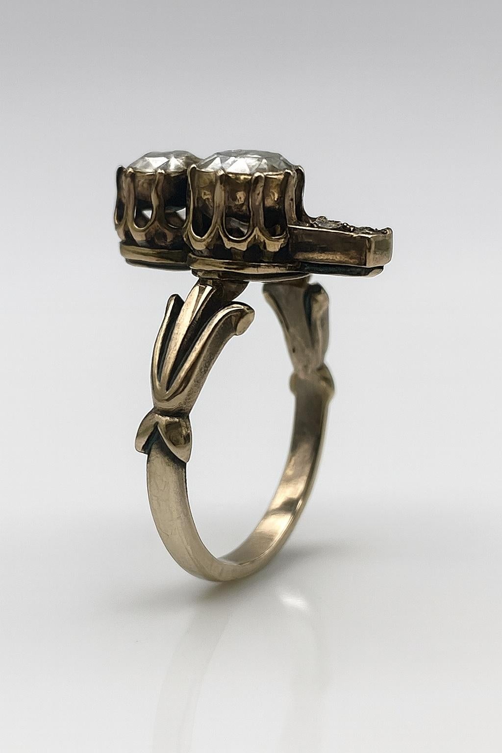 Cette authentique bague Art déco, datant des années 1930, présente un motif caractéristique en forme de trèfle, serti de diamants anciens de taille rose. Réalisée en or 9 carats avec une belle patine vieillie, la bague présente un poids total de