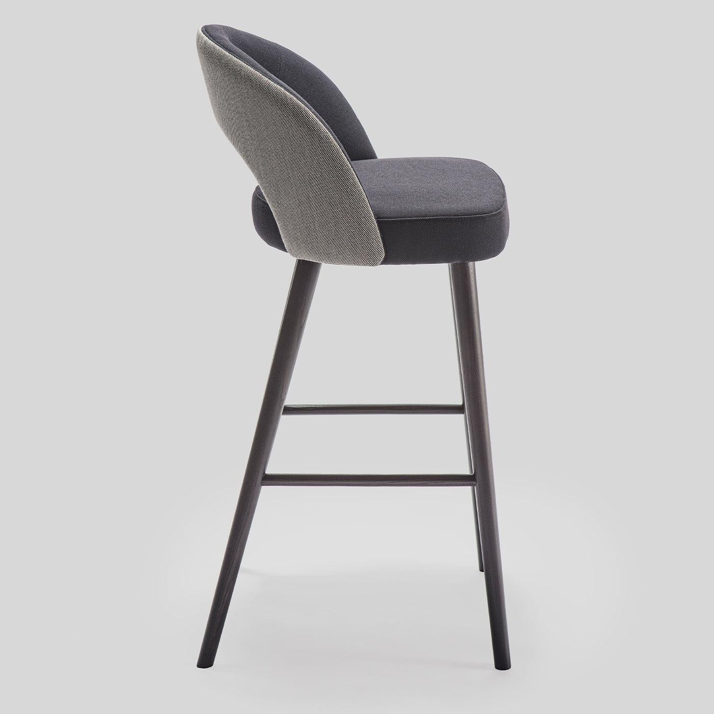 Perfect for pairing with a modern dining room/bar area, this chic stool will infuse elegance into any home. The solid ash wood frame supports an embracing back with a cut-out detail and flows into four tapered legs finished in black. The backrest is