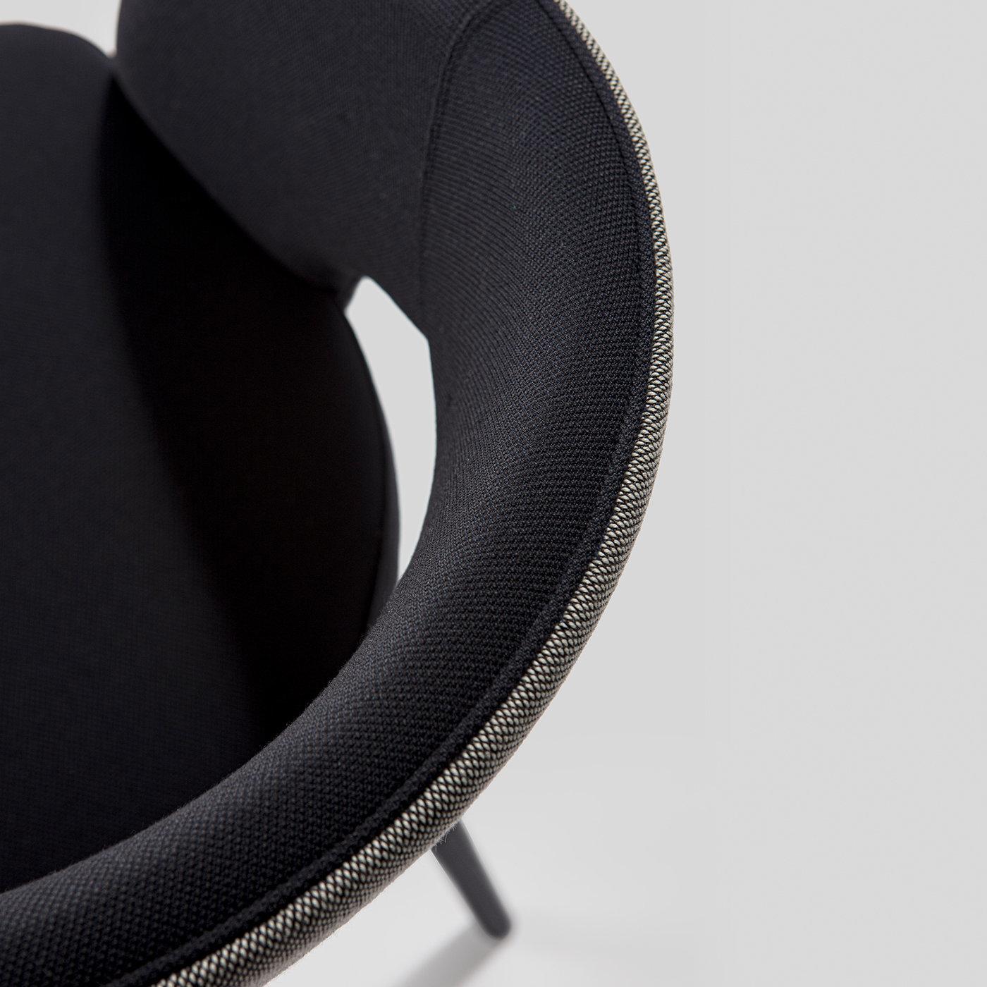 Design meets durability in this mid-century-inspired dining armchair that will be a dramatic and luxurious addition to both a dining room and office decor. The tailored styling is versatile and inviting, featuring a plush anthracite gray upholstery