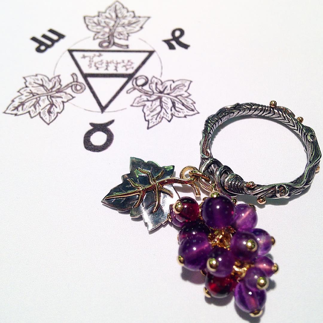 Ring rail in patinated silver and white gold featuring an amethyst and garnet representing a bunch of grapes with its vine leaf.