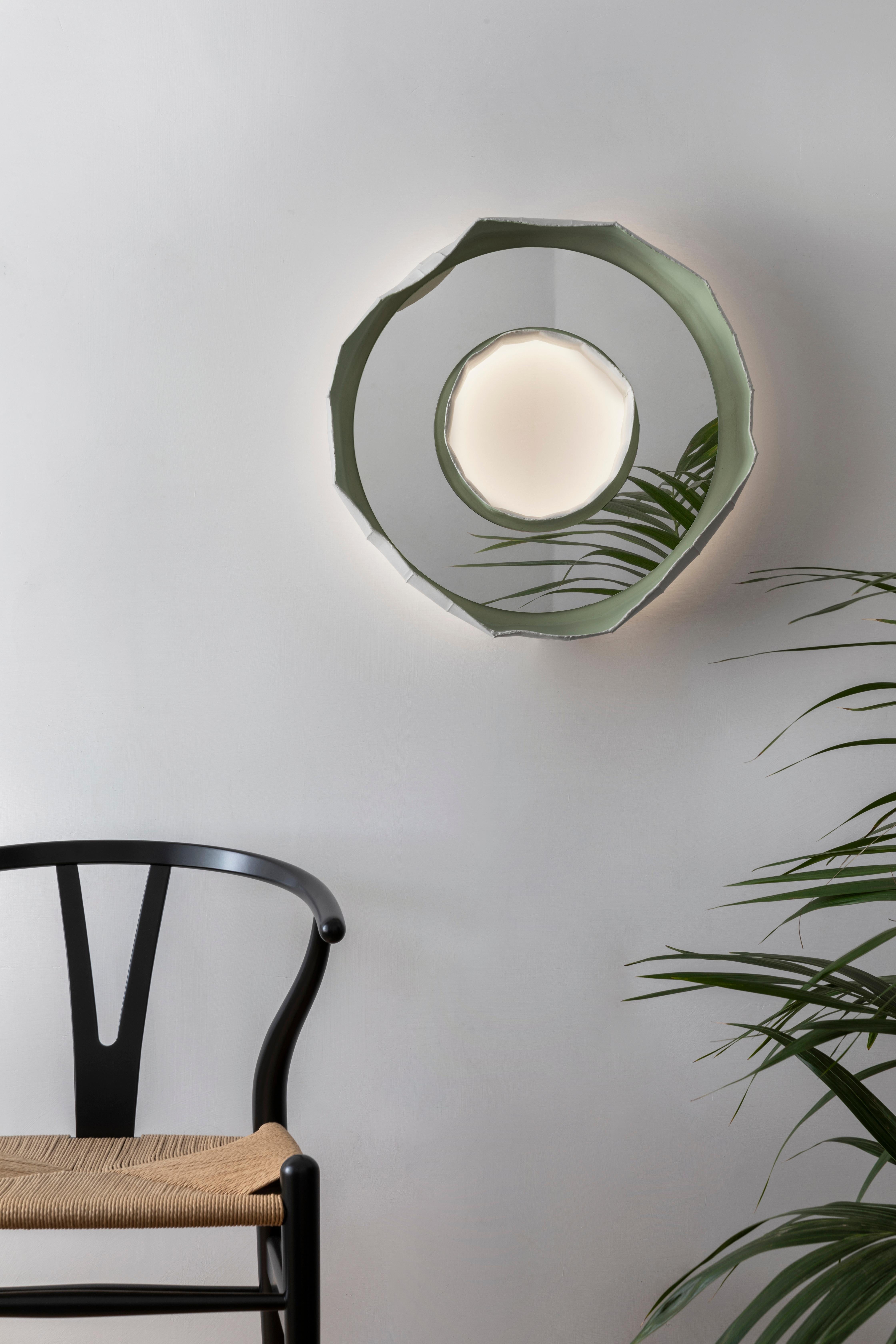 Ring Aura, a stunning mirror-lamp handmade in Italy, one of 2 designs that make up the collection REFLECTIONS, the result of a collaboration between artist Paola Paronetto & designer Giovanni Botticelli, that integrates ceramic with colour, glass