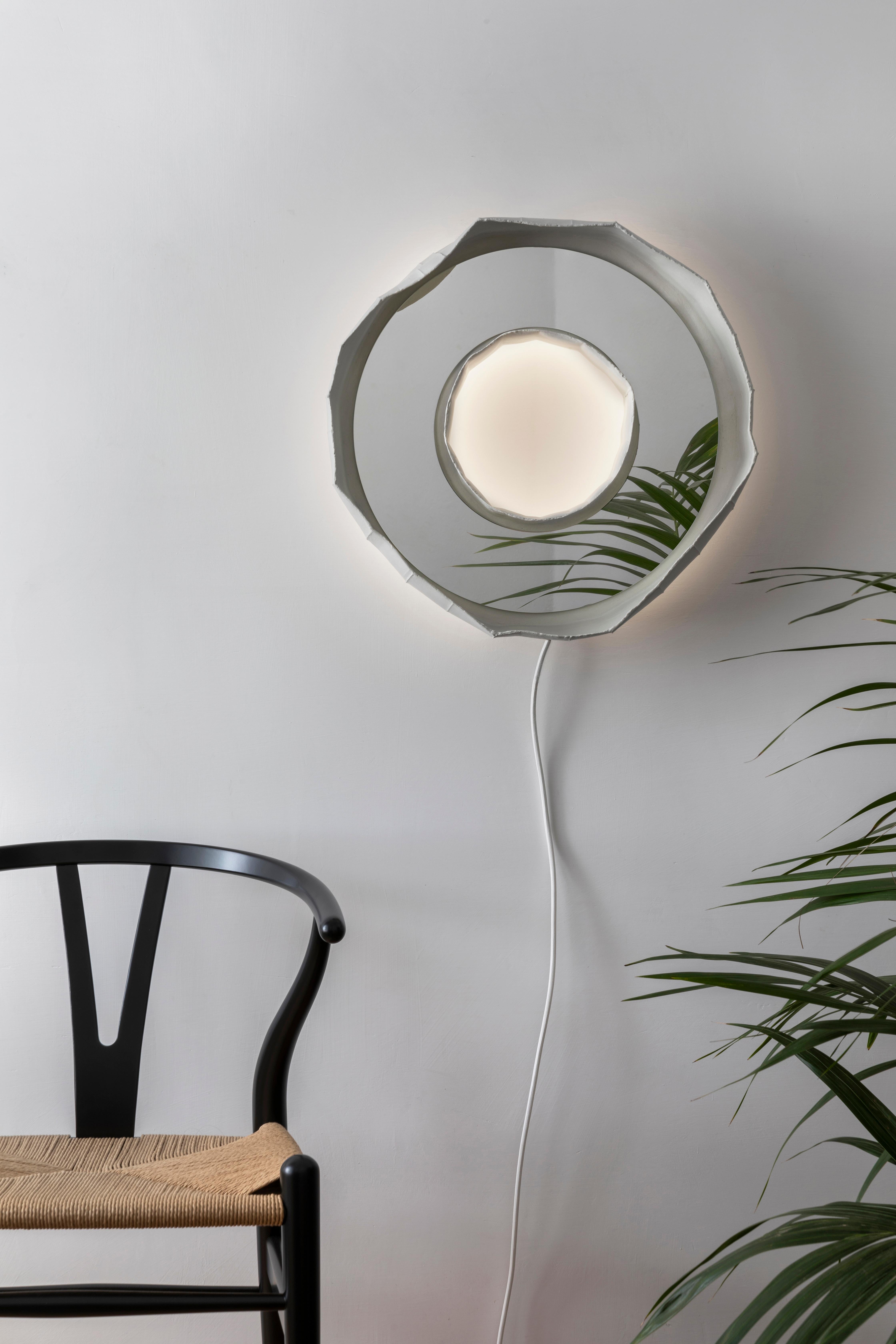 RING AURA, a stunning mirror-lamp handmade in Italy, one of 2 designs that make up the collection REFLECTIONS, the result of a collaboration between artist Paola Paronetto & designer Giovanni Botticelli, that integrates ceramic with colour, glass